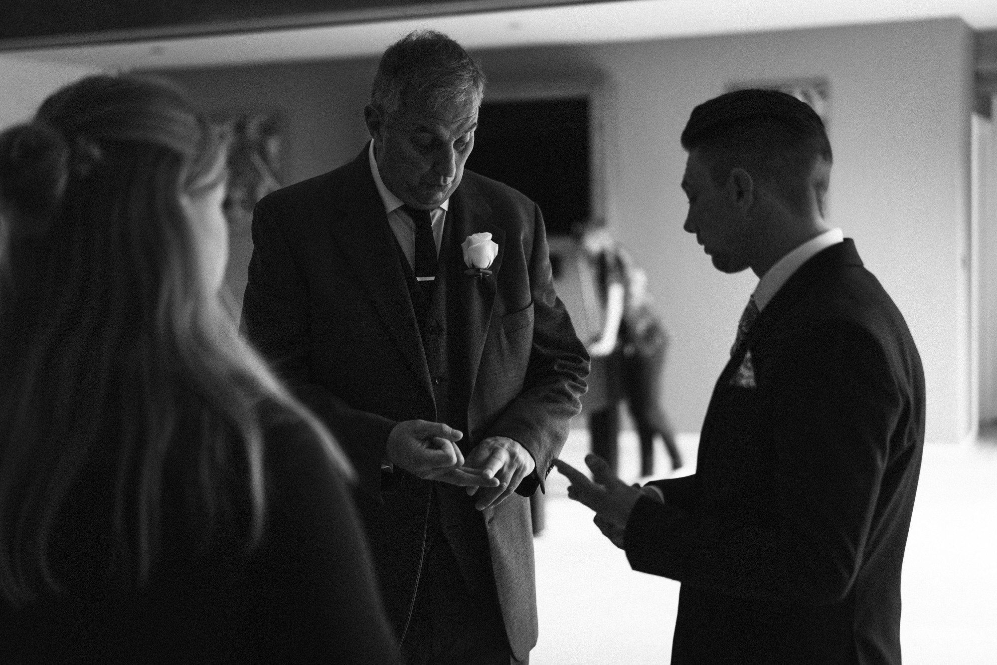 The groom and his father work out who needs button hole flowers