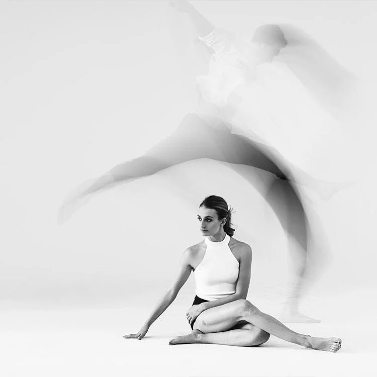 Gabrialla Papadakis sits on the floor while her dance partner leaps through the air above her, he is blurred as he is in motion