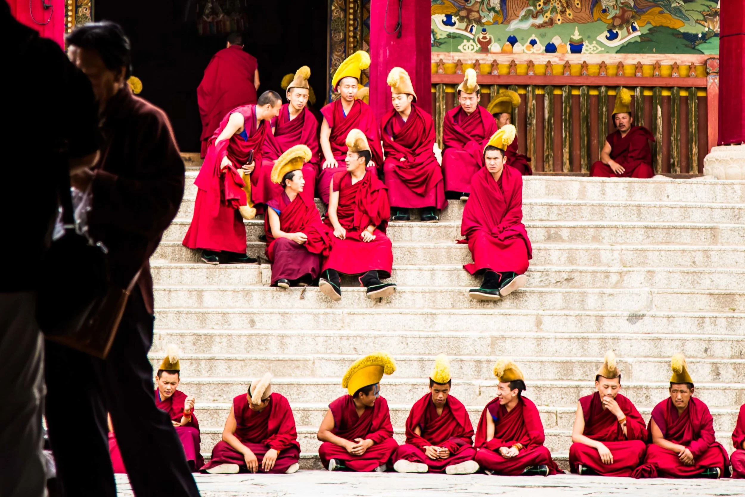 Monks, wearing their yellow hats, assemble to chant before entering the main hall.