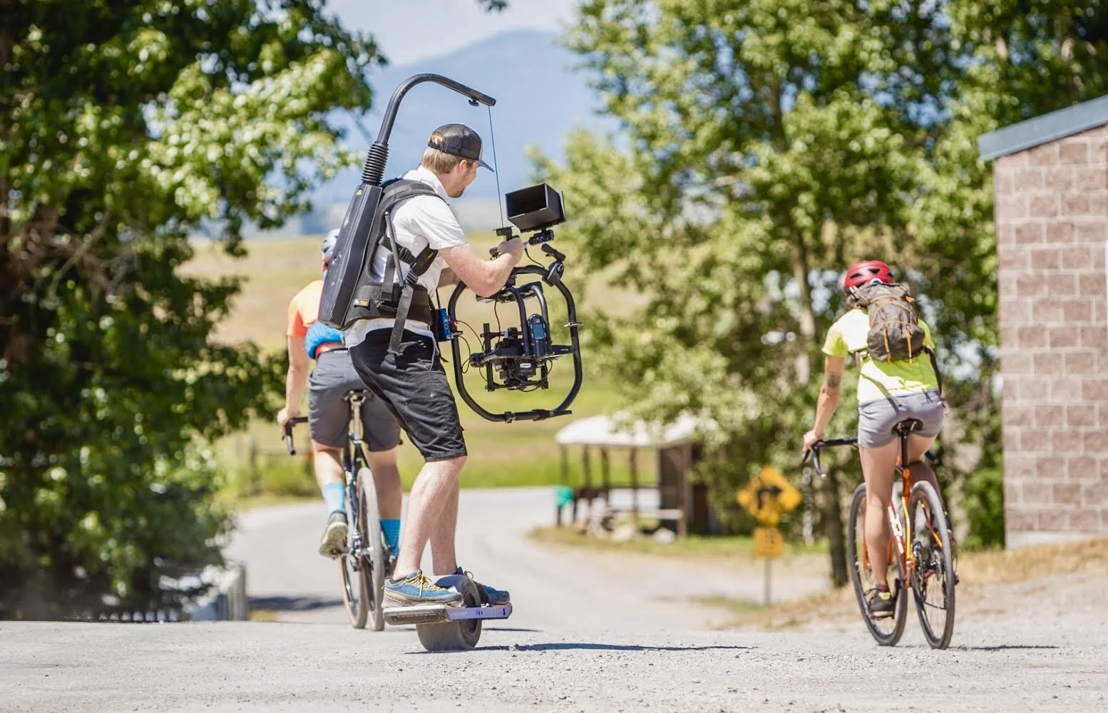 John Sweeney riding a one wheel to capture cyclists for Montana Tourism Commercial - John Sweeney Cinematography