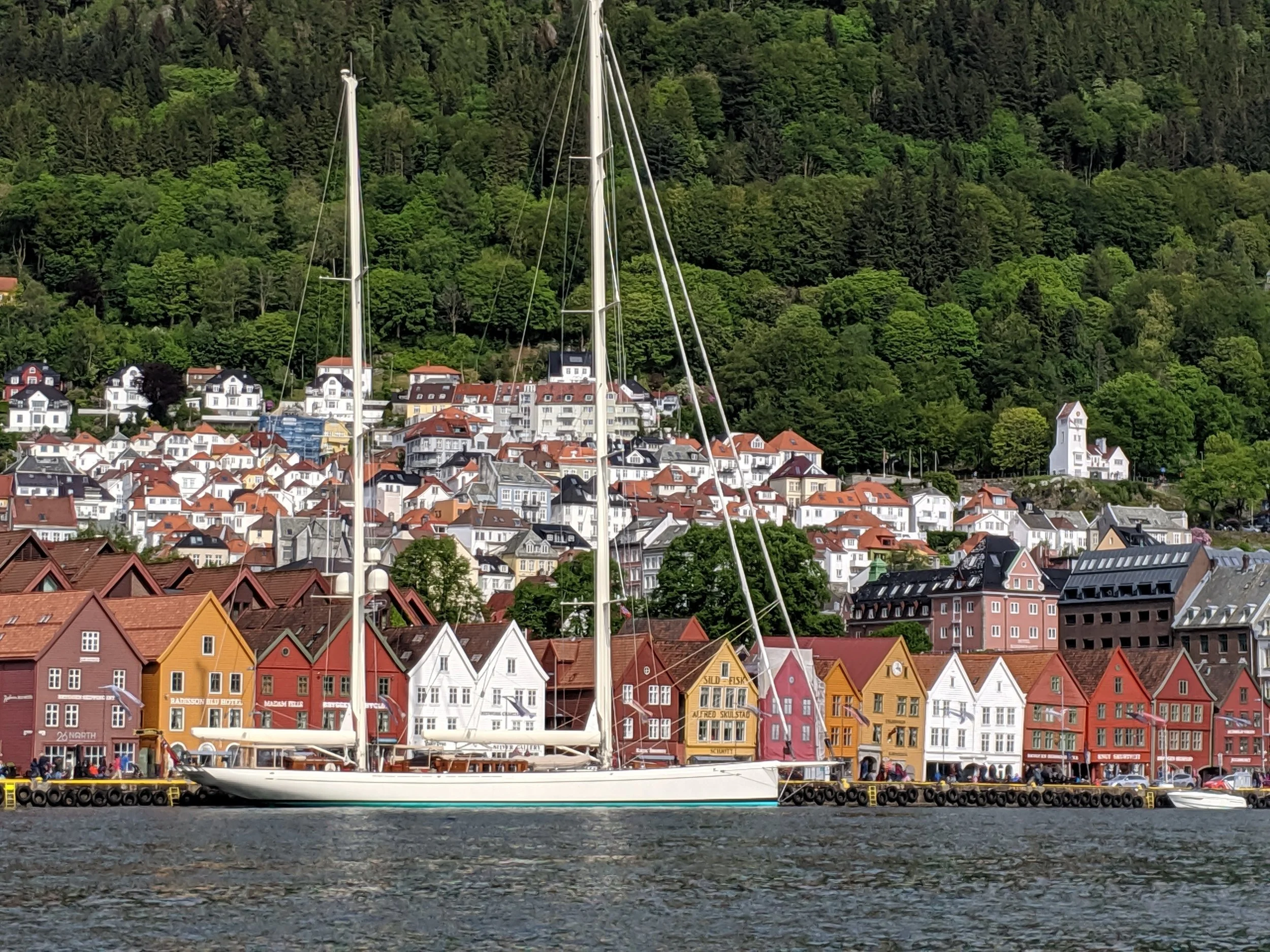 The buildings along the harbor are old wooden structures that have been maintained/recreated to look like the ones that existed several hundred years ago. They are tilted and leaning due to their age the settling of soil beneath them.