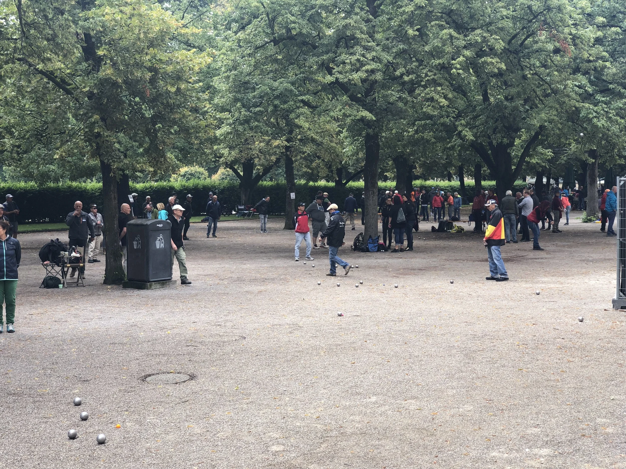 Germans love play a game called petanque, In this area of a city park in Munich there were at least 100 people playing petanque.