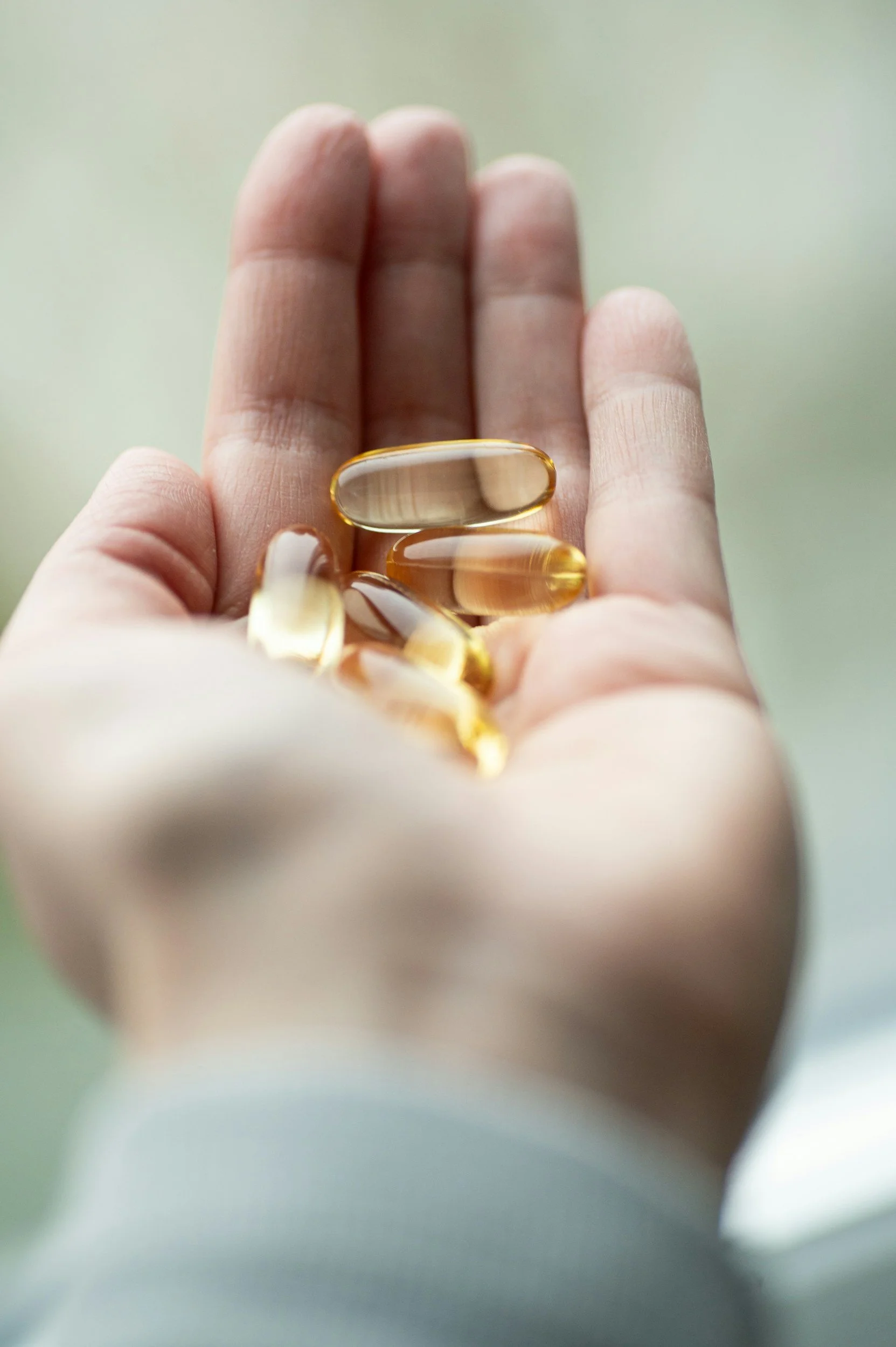 A picture of a hand holding supplements, which can be useful to remedy low levels of vitamins and minerals that affect mental health.
