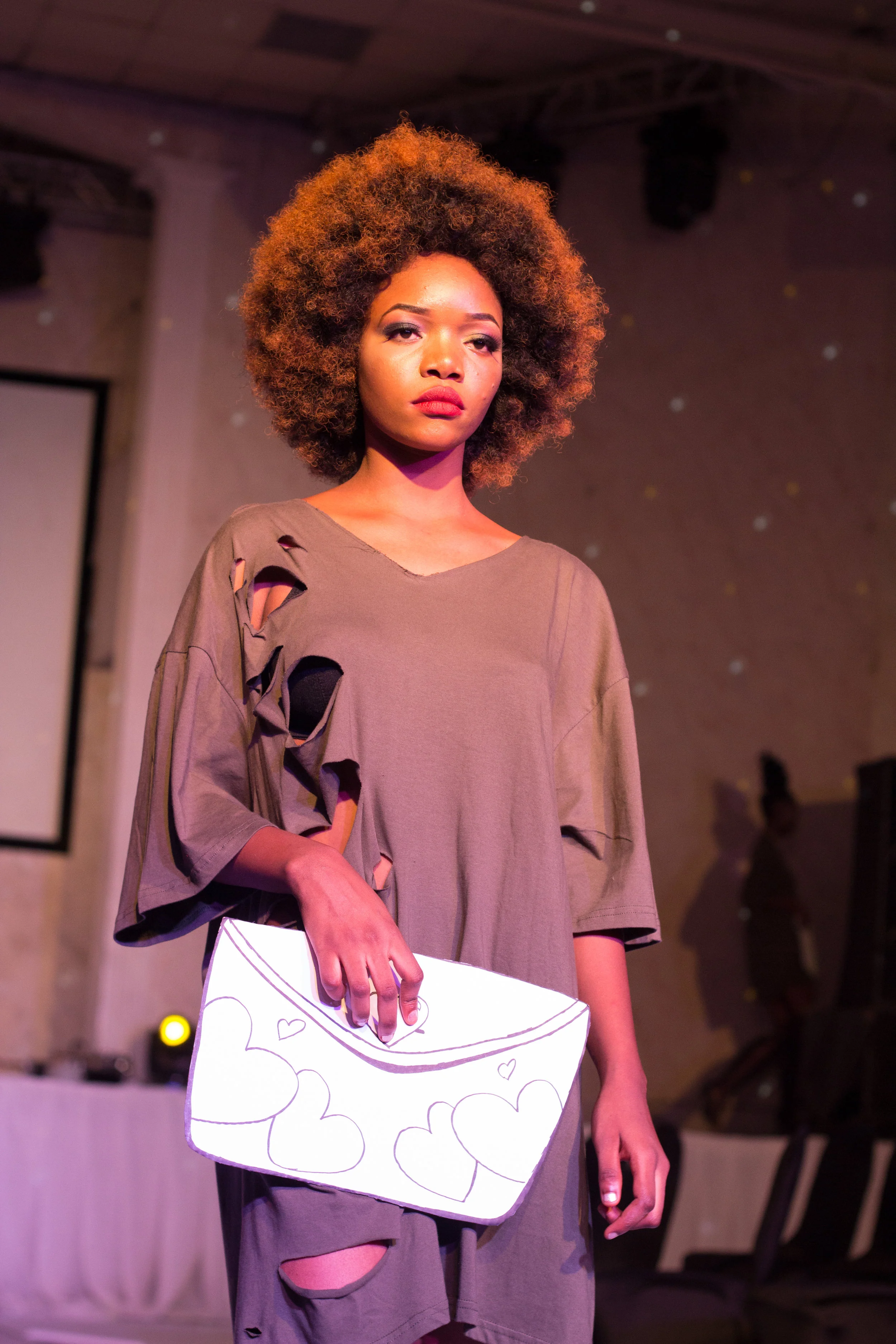 Nigerian Model in Pre-Show @ The Eleventh Fashion Show wearing VonRay Designs Distressed Tee Dress and Paper-doll bag Illustrated by Dennis Robinson II of D2Artz & VonRay Designs; PHOTOGRAPHER- Ebiye Wilson Jeke of Wilson Photography (@wilsonjekephotography)