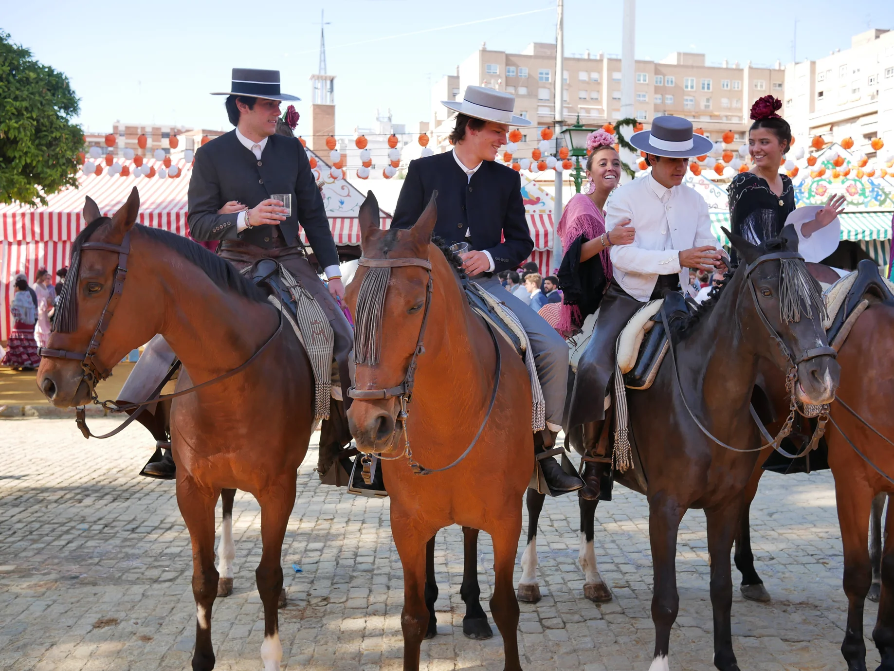 Here’s a group socializing with drinks (probably rebujito), with girls riding behind them.