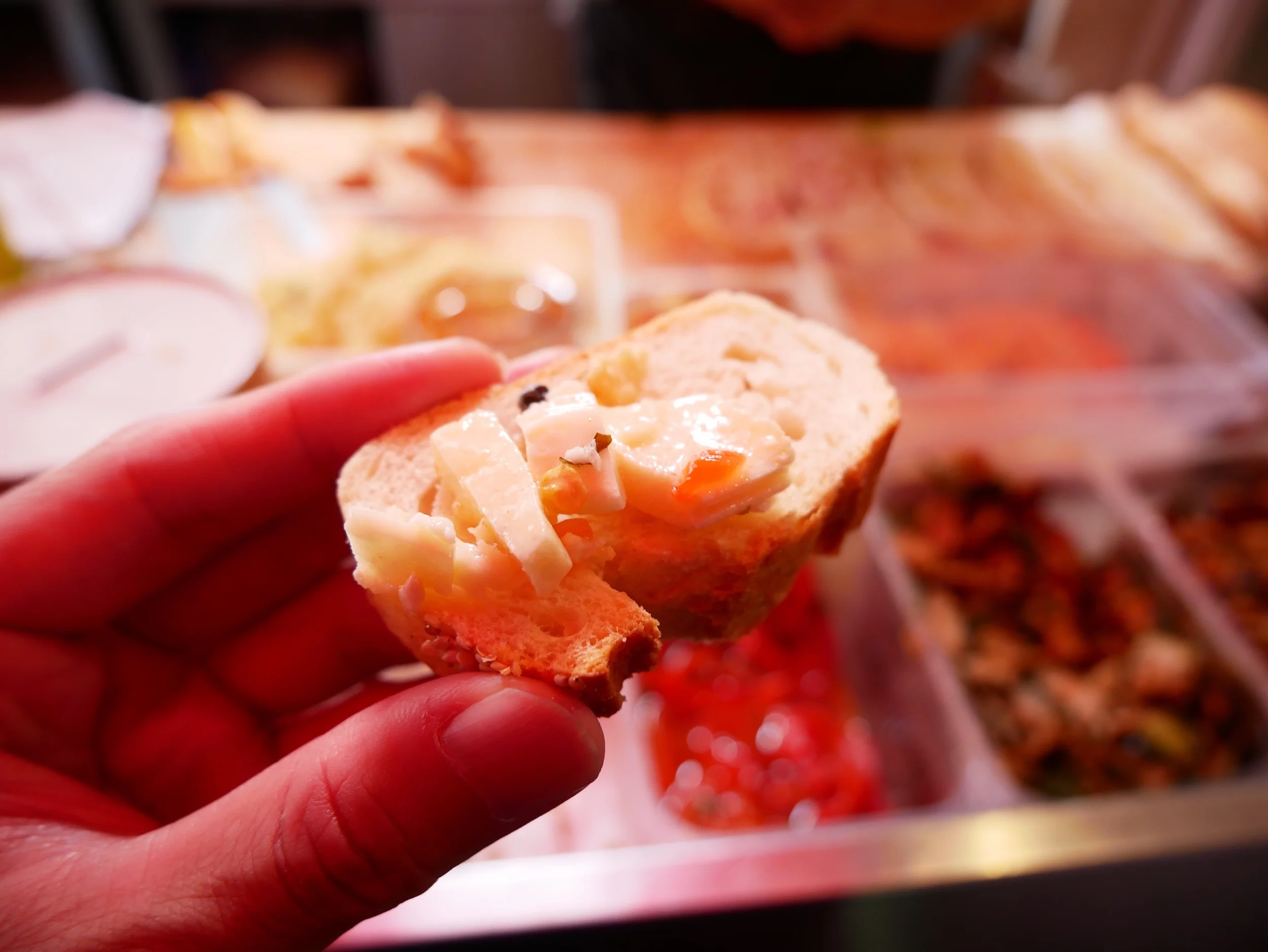 Here he’s giving us samples of a firm, marinated cheese.