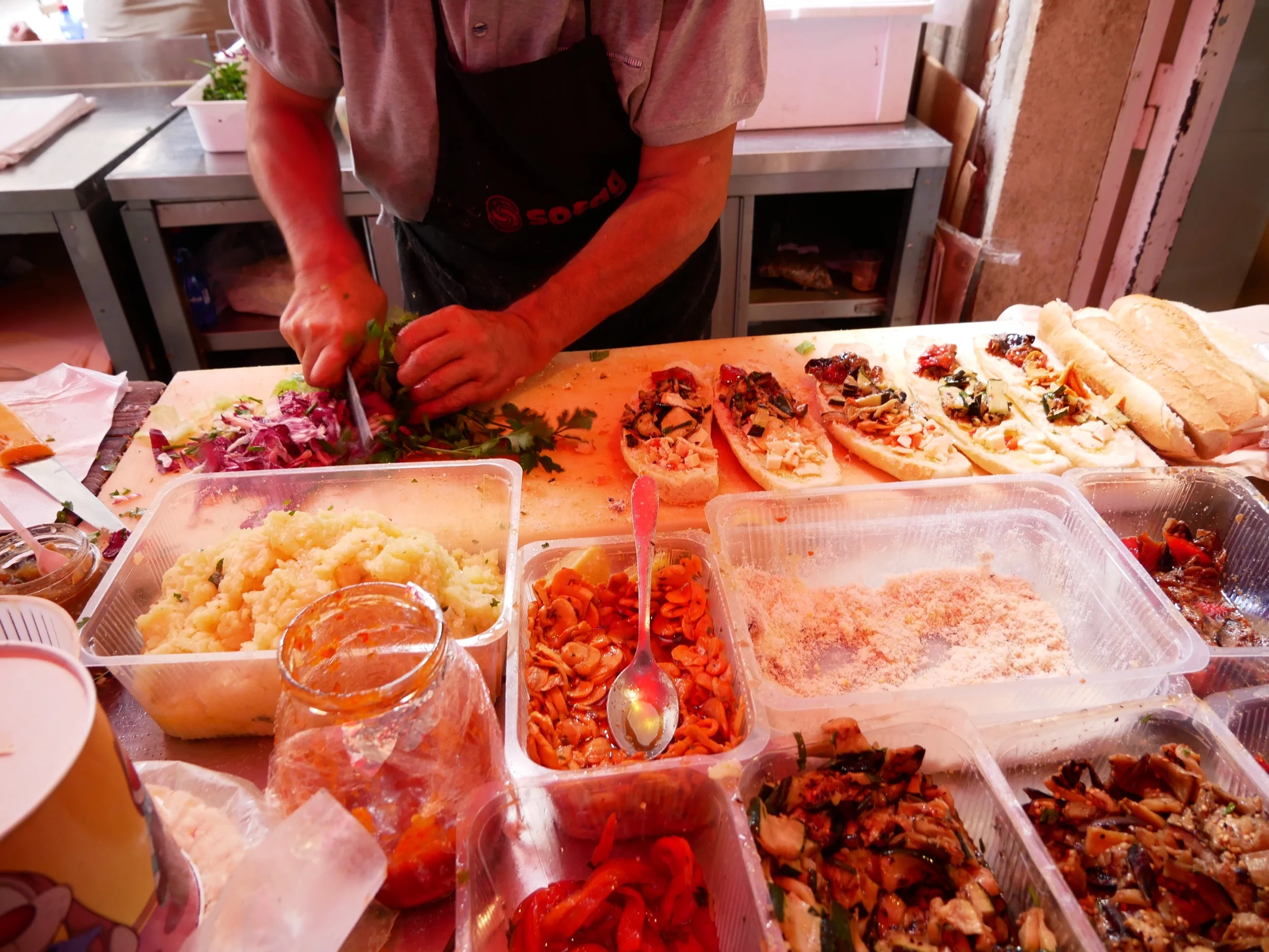 Then Andrea reached behind him and grabbed a bunch of lettuce, radicchio, and parsley, and roughly chopped them.