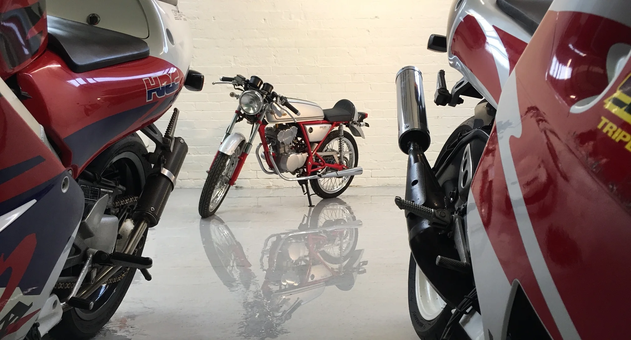 Dream 50 between sports bikes wet floor 2.JPG