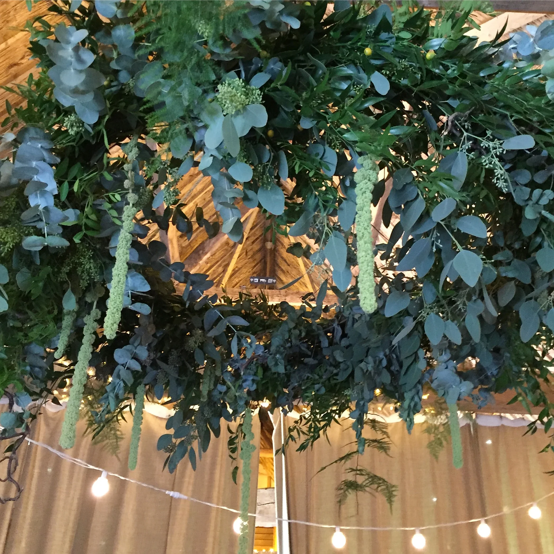 Hanging chandelier full of eucalyptus, ferns and amaranthus