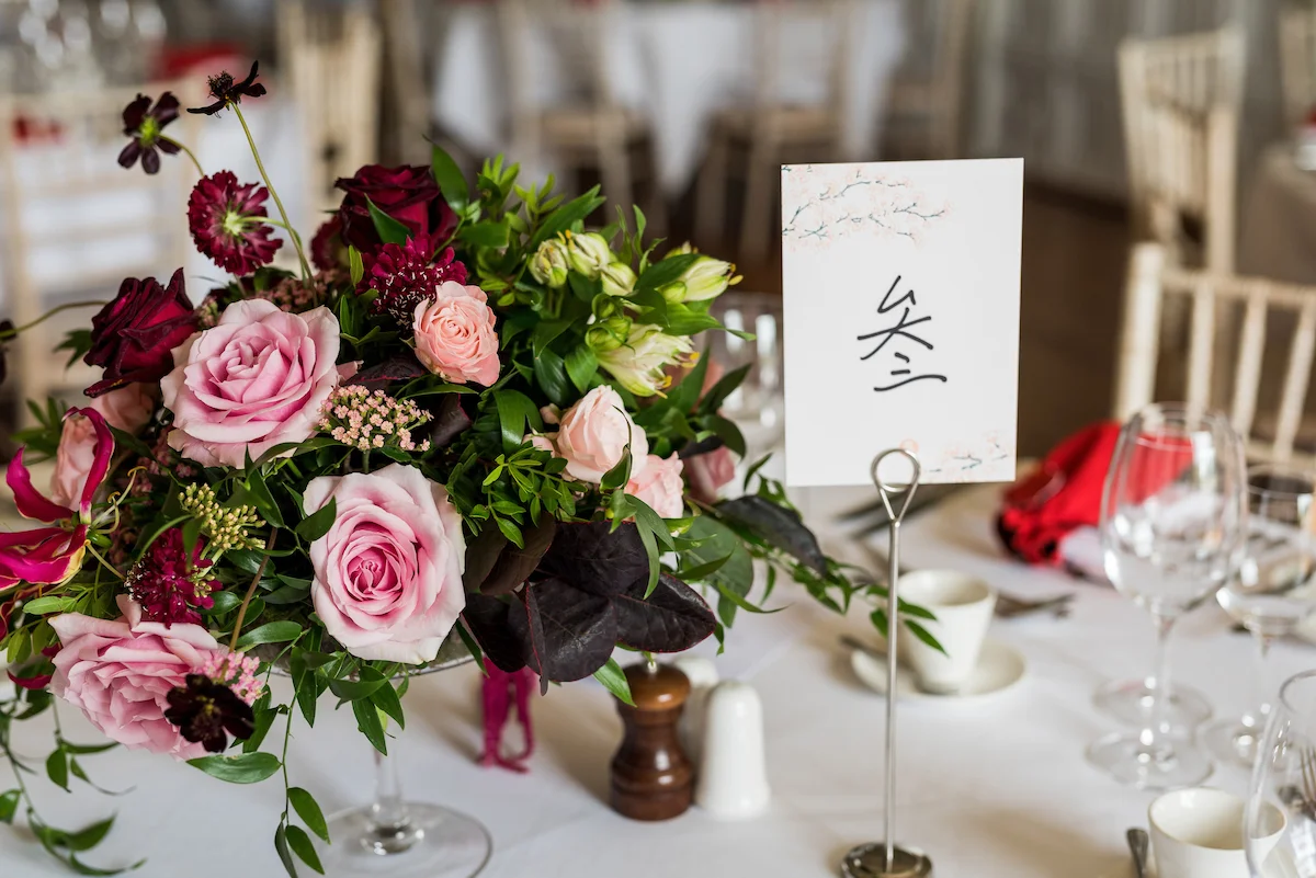 Blush, pink and crimson wedding table centrepiece by The Flower Story