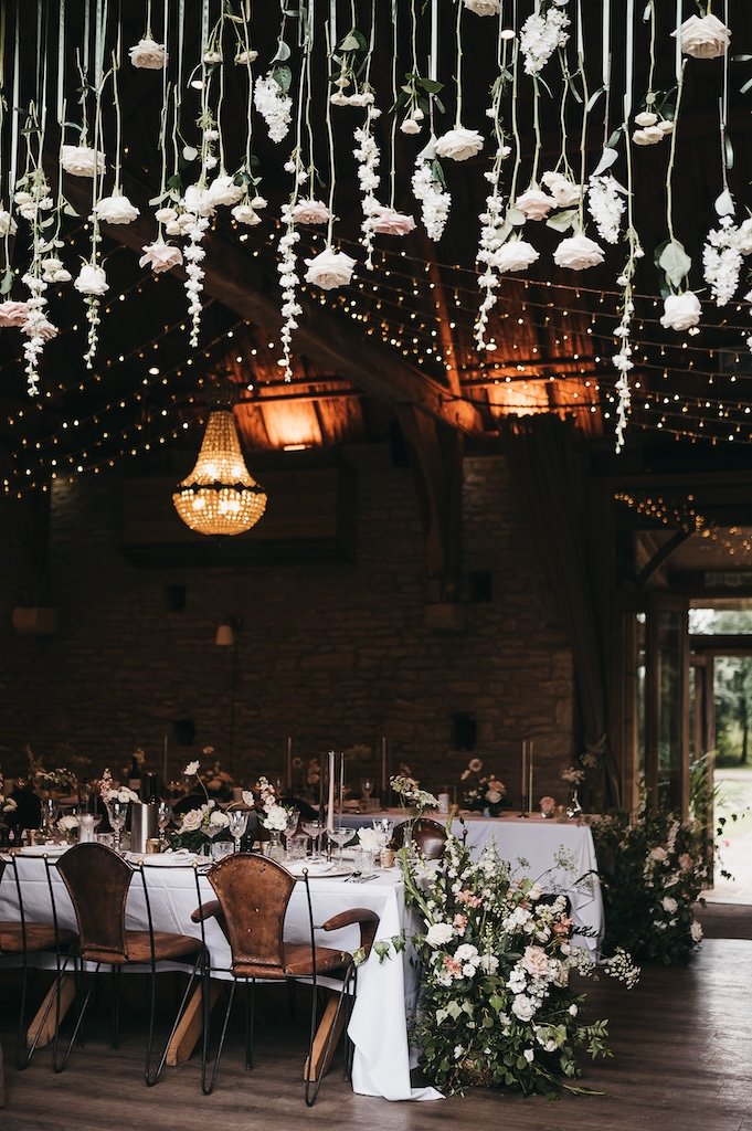 Hanging flowers forming a wedding arch across open barn doors
