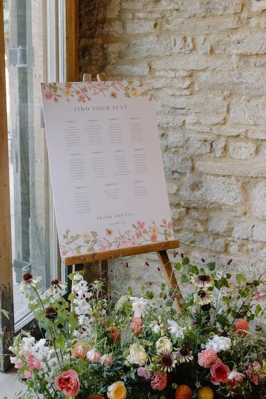 Colourful garden style flower meadows sitting at the base of a wedding table plan