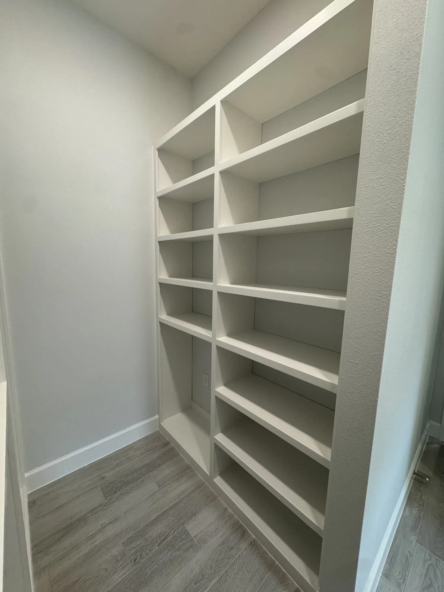Walk-in closet with a tall column of built-in shelves