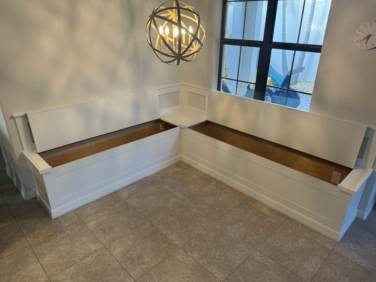Built-in banquette with seat lids open showing storage