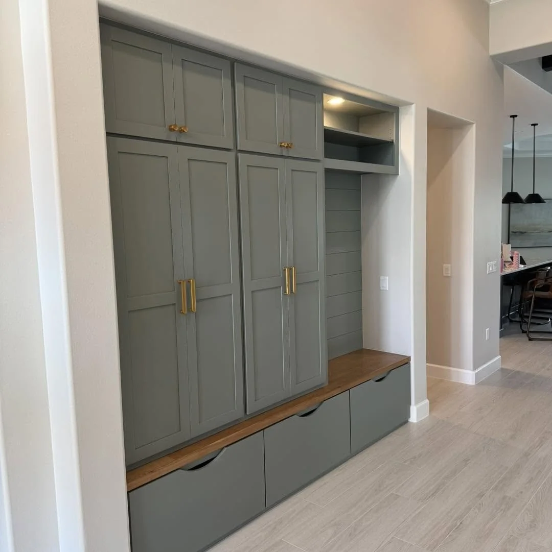 Sage-green mudroom lockers with bench and upper cabinets