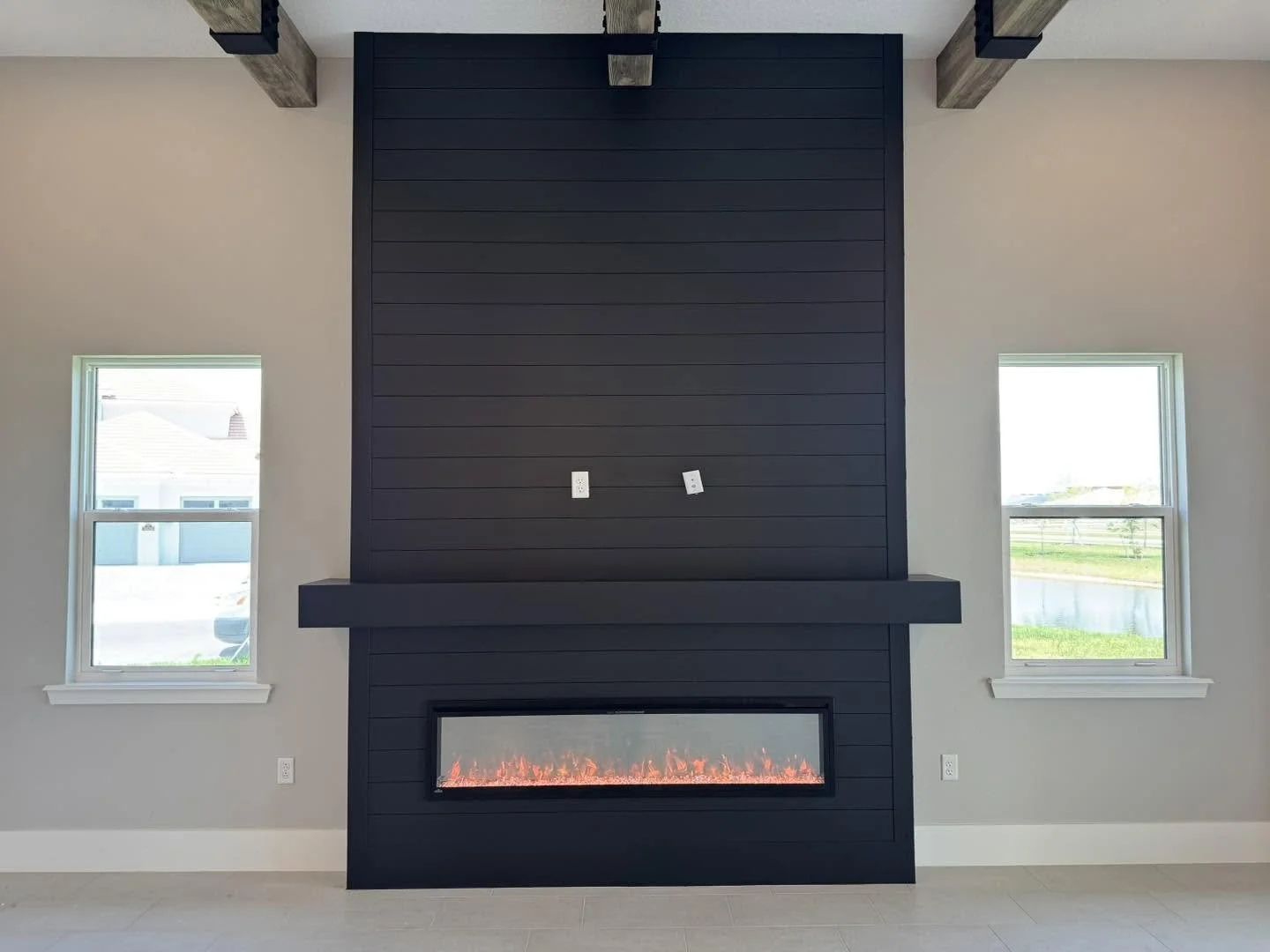 Black fireplace wall with mantel and electric fireplace