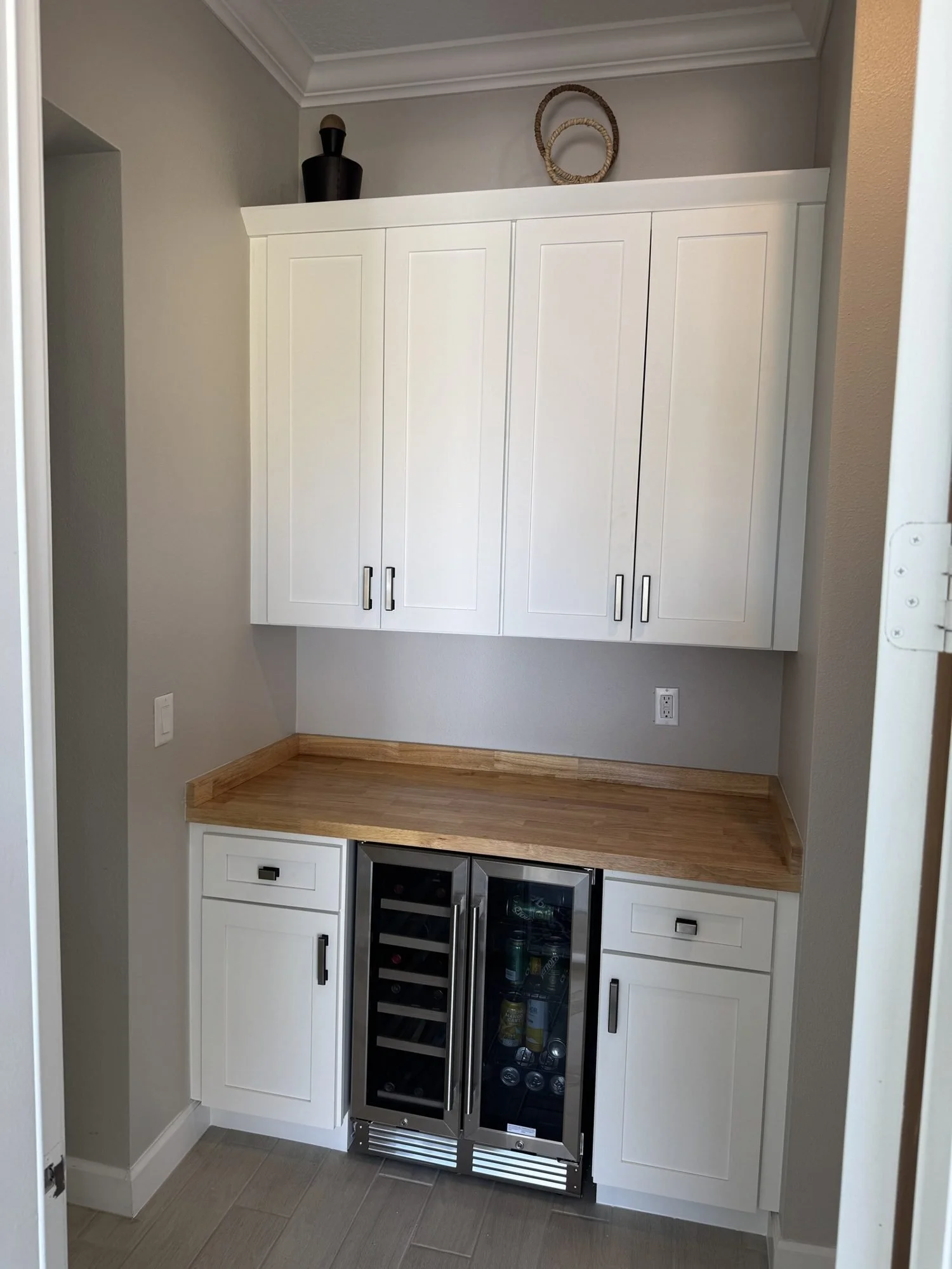 Built-in dry bar nook with butcher-block counter and wine fridge