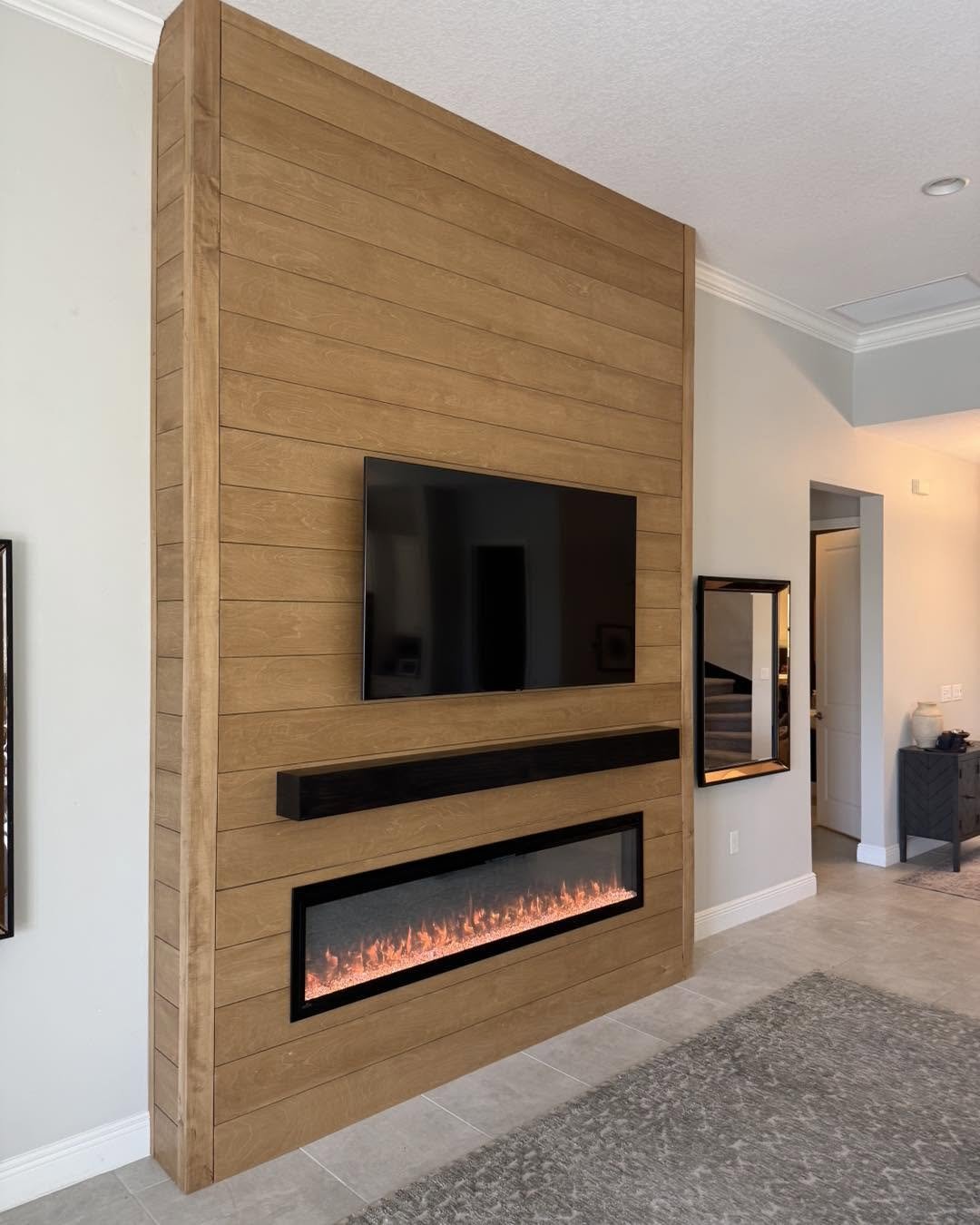 Wood-clad fireplace and TV wall with floating mantel