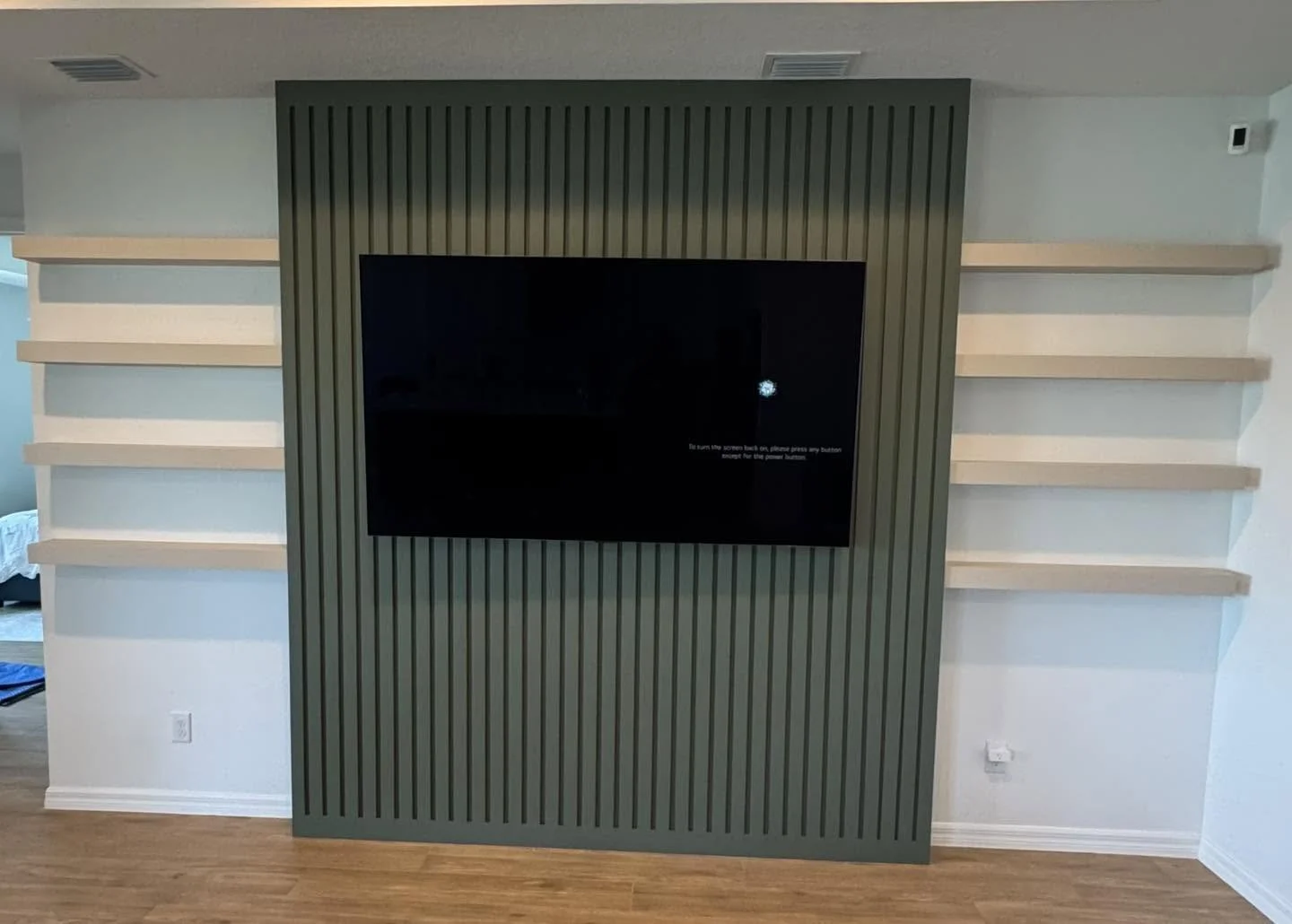 Green slat TV accent wall with floating shelves