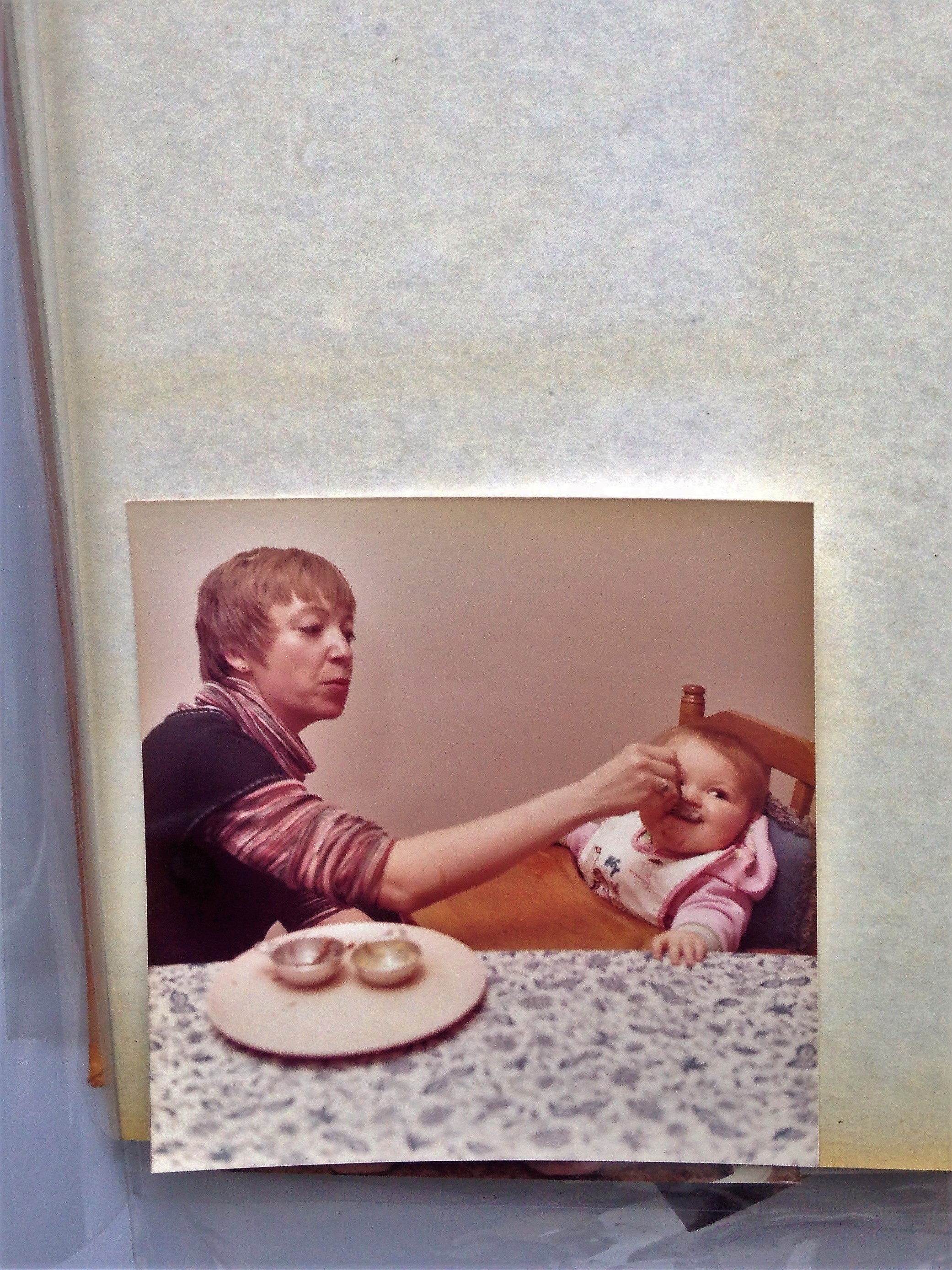 You can see a ghostly outline of where a photo used to be in the upper left part of this image. The photo at the bottom has yellowed around its edges. Damaging chemical transfer occurred within this album.