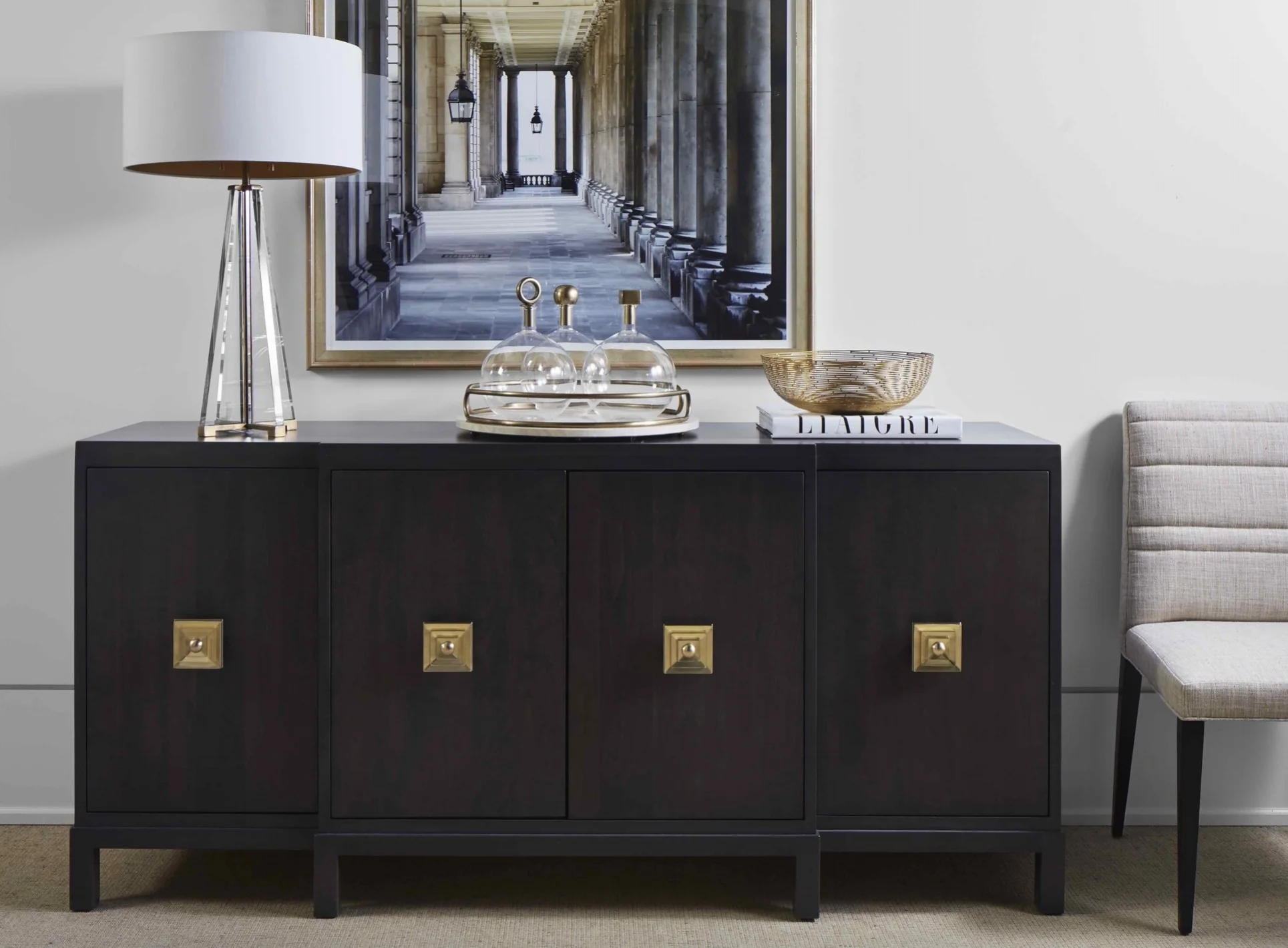 A buffet with stepped front, block legs, deep rich stain and showstopping brass hardware.