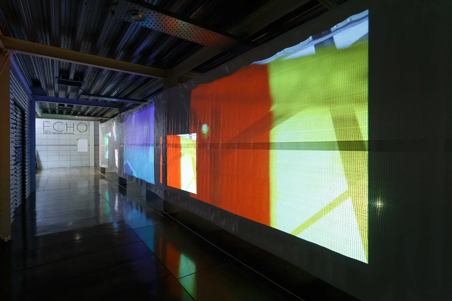 Holly Rowan Hesson, Echo (partial view) , 2017, projection (looped series of 140 stills for each of six projectors), scaffold sheet, steel structure, webbing, lighting gels, dimensions variable