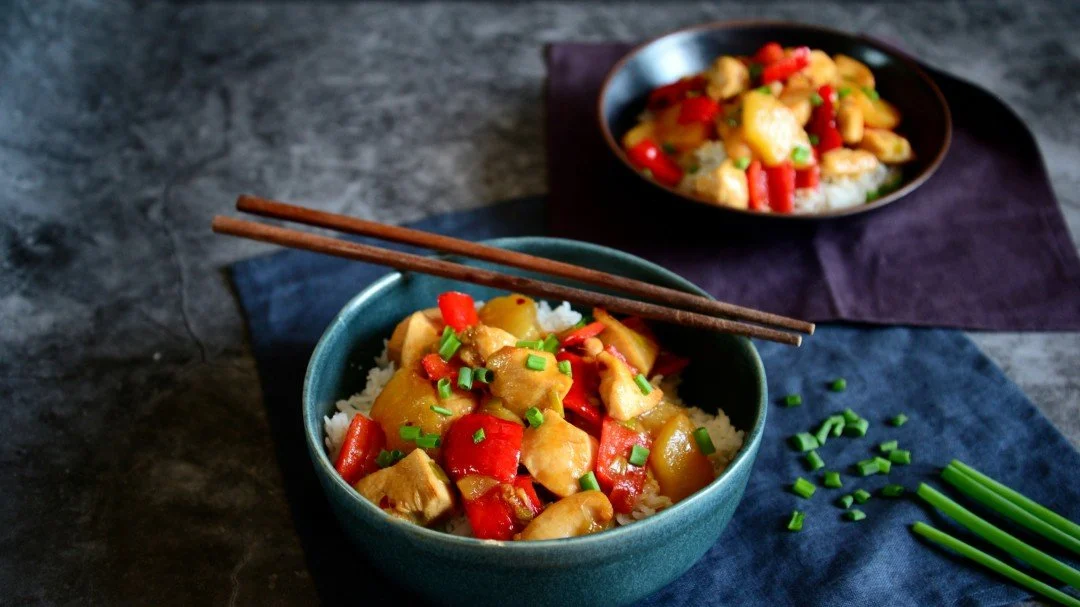 Bowl of low FODMAP sweet and sour chicken with pineapple.