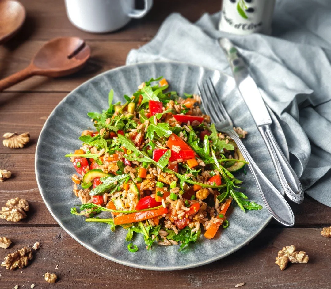 Bowl of gluten free low FODMAP rice salad with walnuts and rocket.