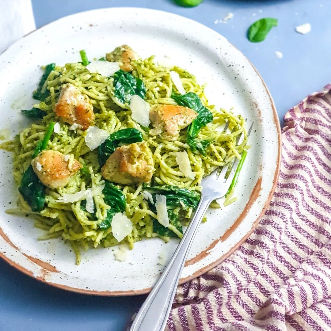 Plate of low FODMAP chicken and pesto pasta with spinach.