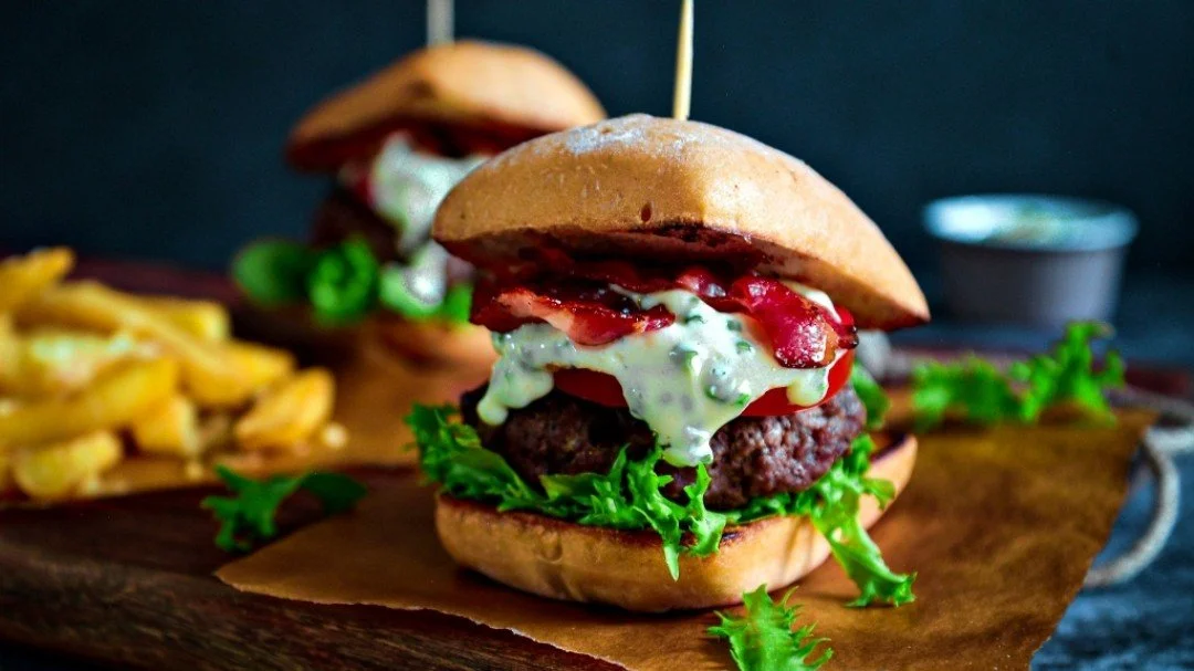 Plate featuring a gluten free low FODMAP beef burger and cheesy fries.