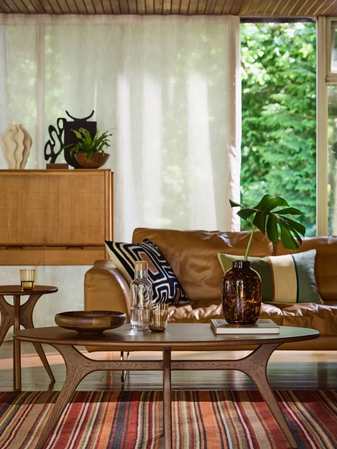 Summer styling at its best. Warm wood, rich leather and our striped rug create an effortless mid-century look. It&rsquo;s a little different from the classic English interiors we usually see our rugs in, and I love this fresh take in this @johnlewis 