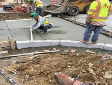 Finishing concrete on newly installed alley entrance, stations 15+75 to station 15+90