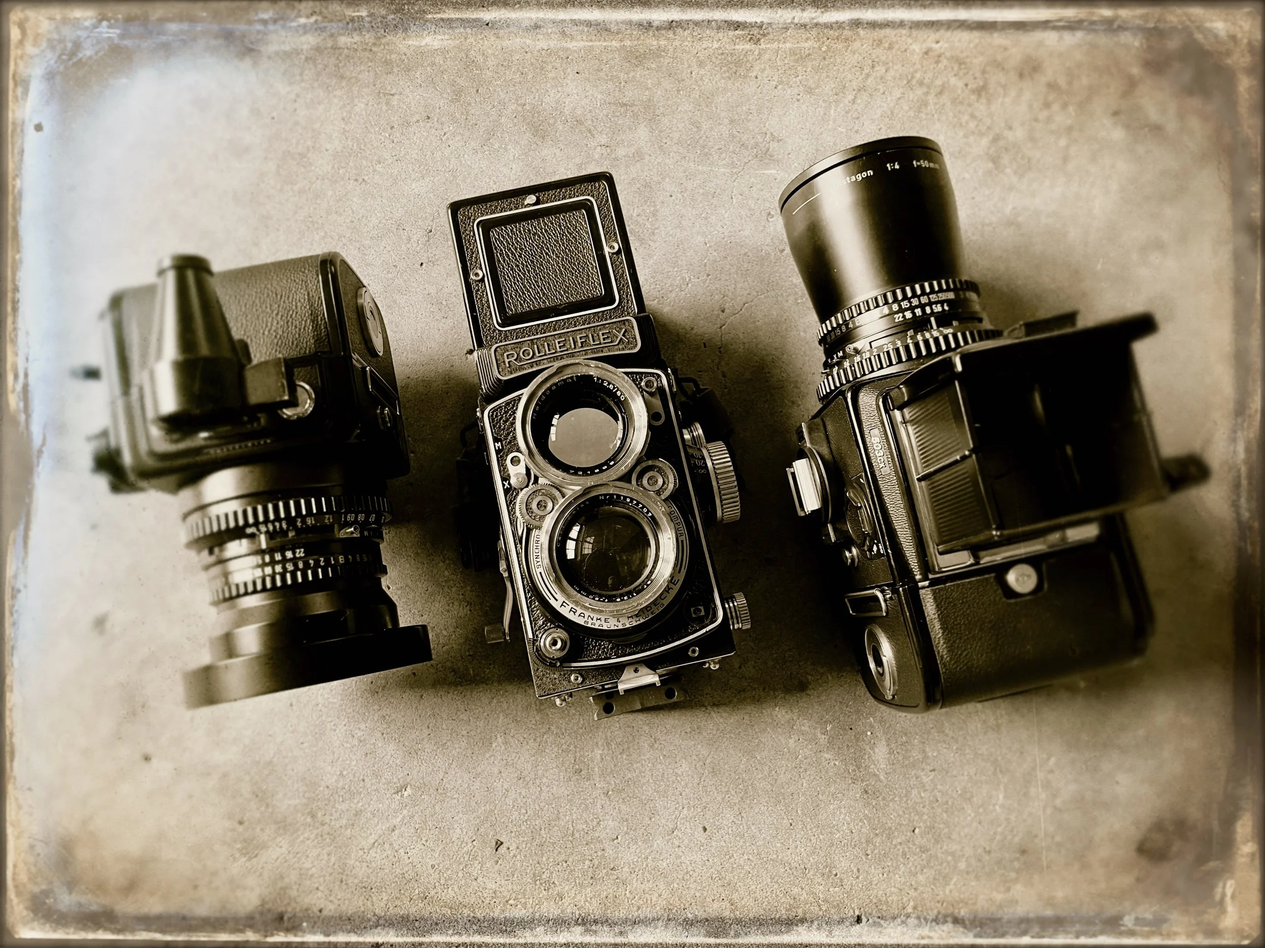 Drei klassische Analogkameras für das Mittelformat 6x6 cm: Hasselblad SWC Supereitwinkelkamera mit Sucher, eine zweiäugige Rolleiflex 2,8 mit dem legendären 2,8/80mm Zeiss Planar sowie eine Hasselblad 503cx Spiegelreflexkamera mit 50mm Distagon