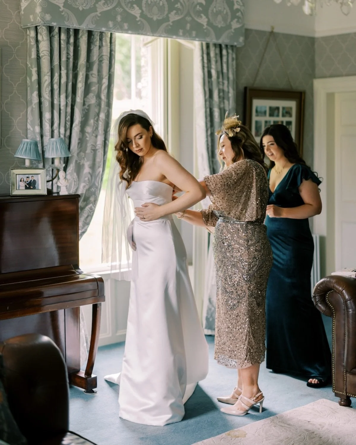 An in between moment caught as mom and sister adjust the fabric of the brides dress with care, smoothing the dress and fastening just before leaving for Waterford castle
.
.
.
.

.
.
.
.
Adare manor castle wedding
Adare manor hotel 
Irish 
irishweddi