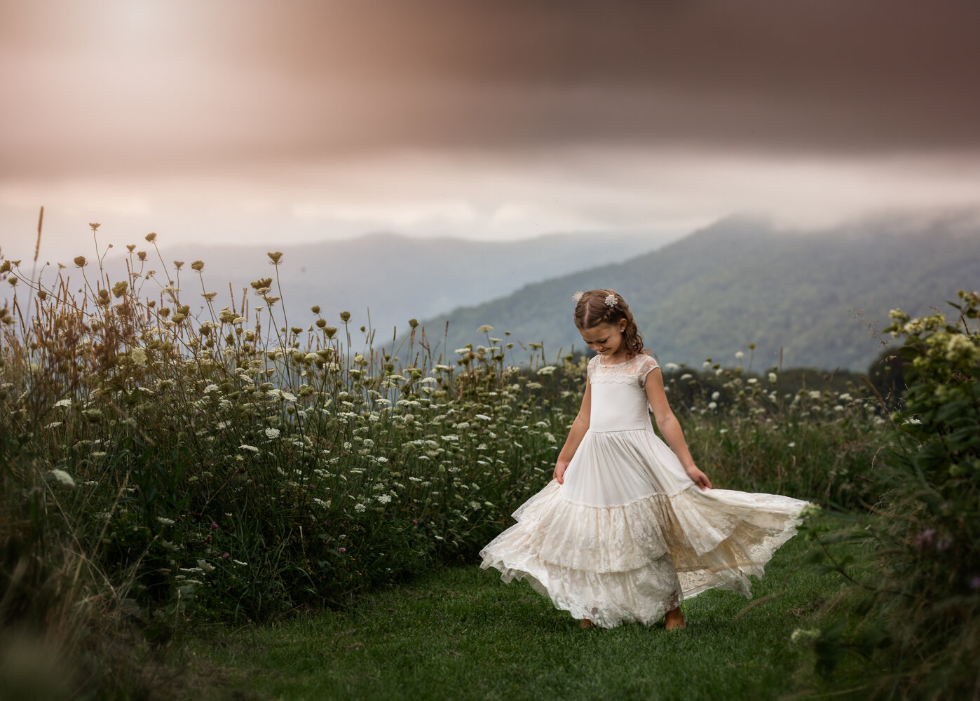Little girl twirling with wild flowers Asheville's Best Child Photographer