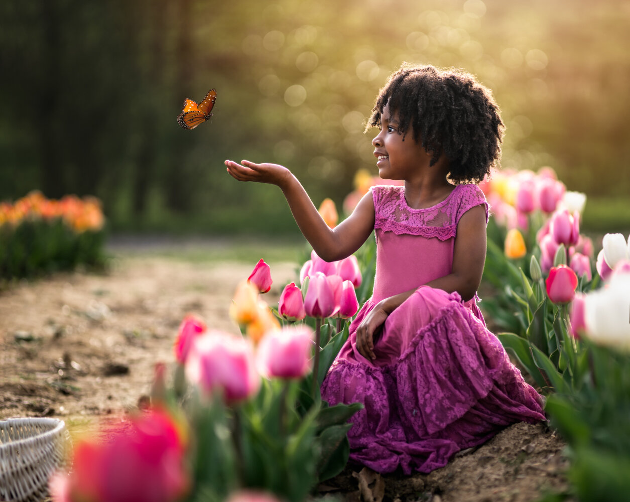 girl playing with butterflies in a flower garden - Asheville Photographer