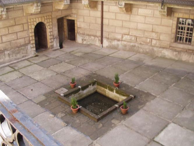  Shot of the center courtyard showing the drainage grate over the original fissure, filled in by rocks and concrete. &nbsp;Some believe it's a water well or fountain, but those who visit don't seem to think so. &nbsp;Photo by  No. 666  