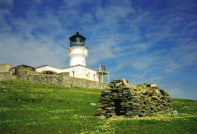  The lighthouse with the stone chapel built by  St. Flannan  in the 7th century in the foreground.   Photo Credit  By JJM, CC BY-SA 2.0 