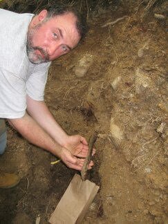  Frank Watson at a part of the archaeological excavation site and a victim they call SK003 