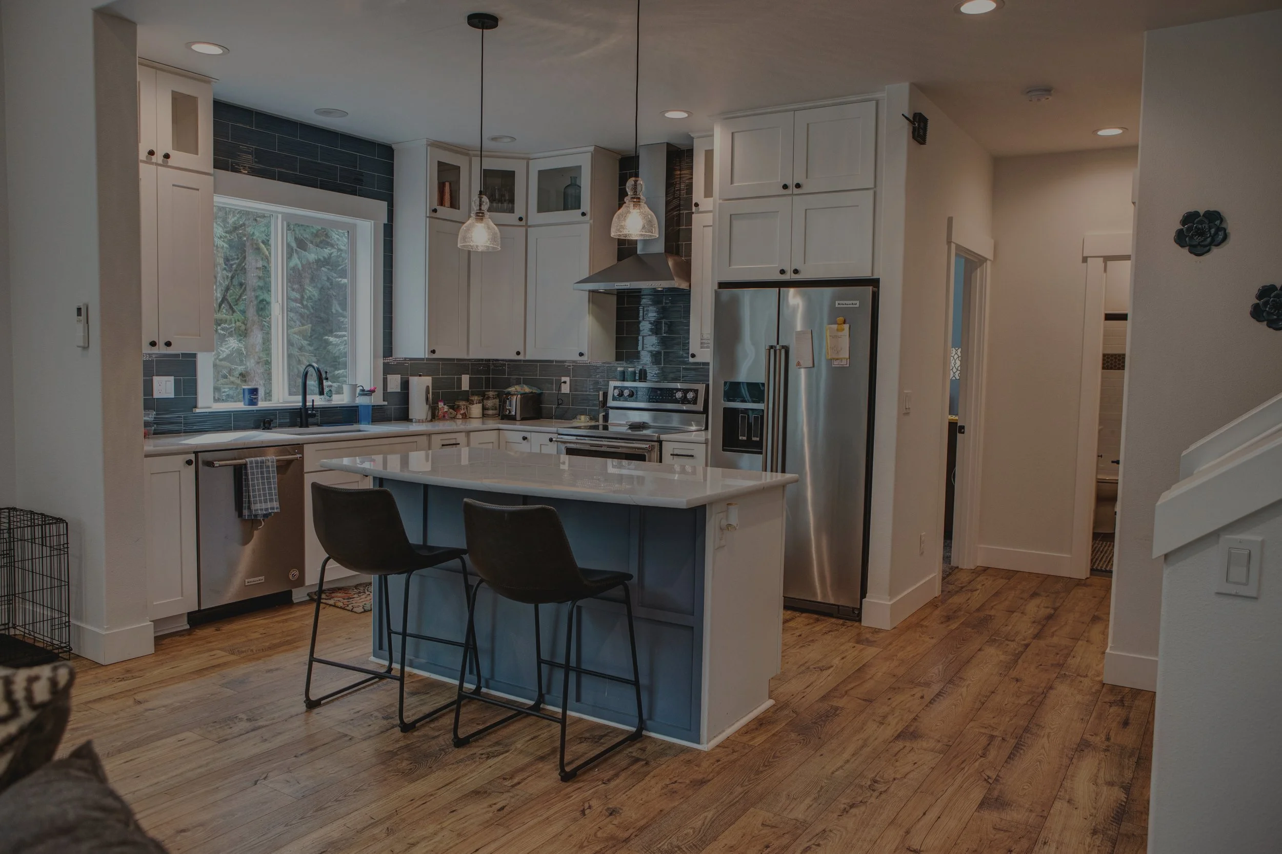 Bobbie's modern custom home in Shelton featuring open concept kitchen with vaulted ceilings and two-tone cabinetry - FoxHead Construction Mason County