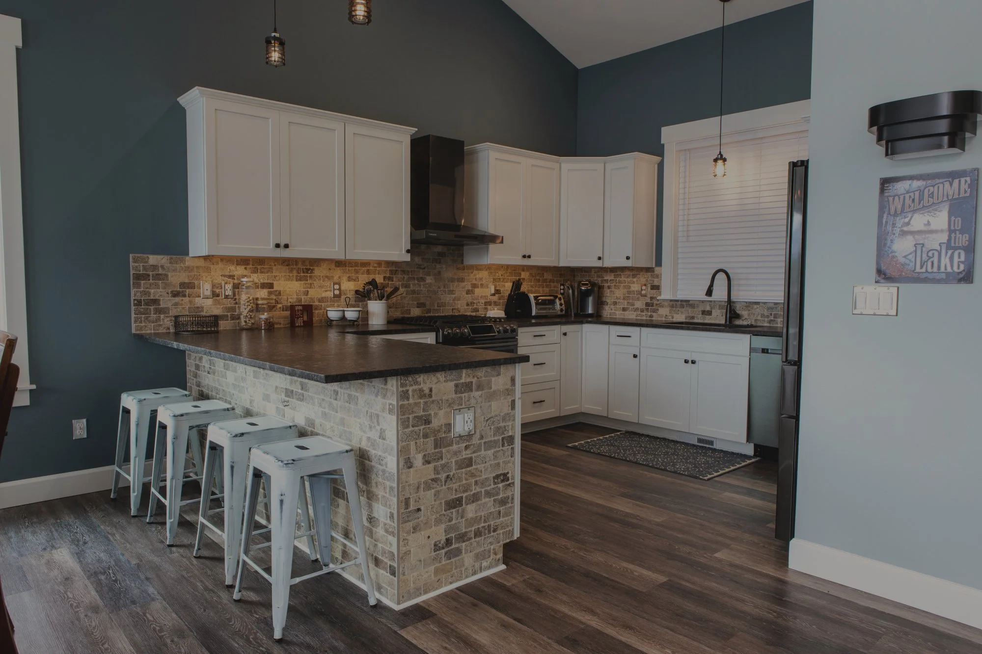 Ross's lakefront custom home on Mason Lake featuring kitchen with stone accent wall and lake views - FoxHead Construction Mason County