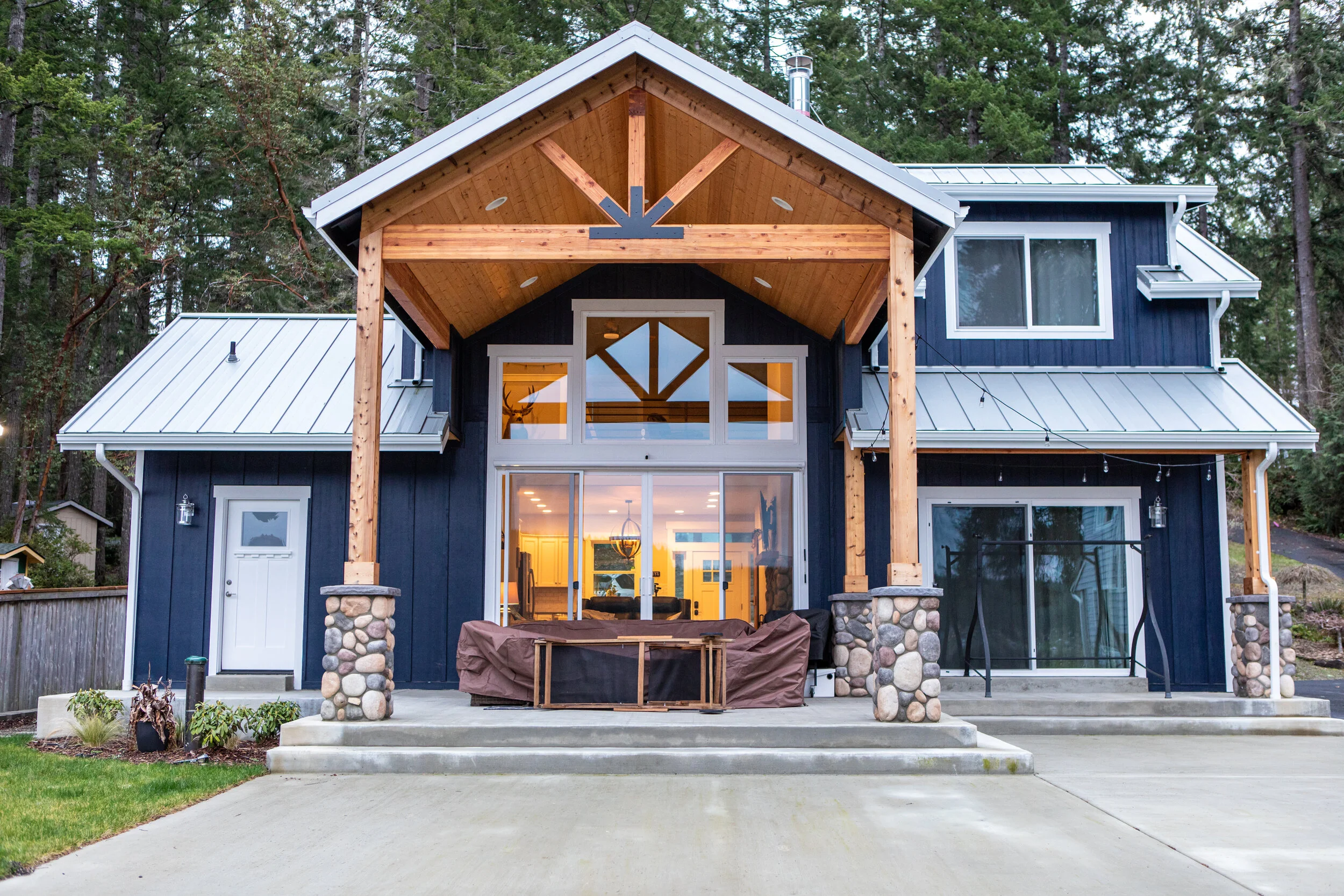 Chris's lakefront custom home on Mason Lake featuring timber frame covered porch with river rock columns - FoxHead Construction Mason County