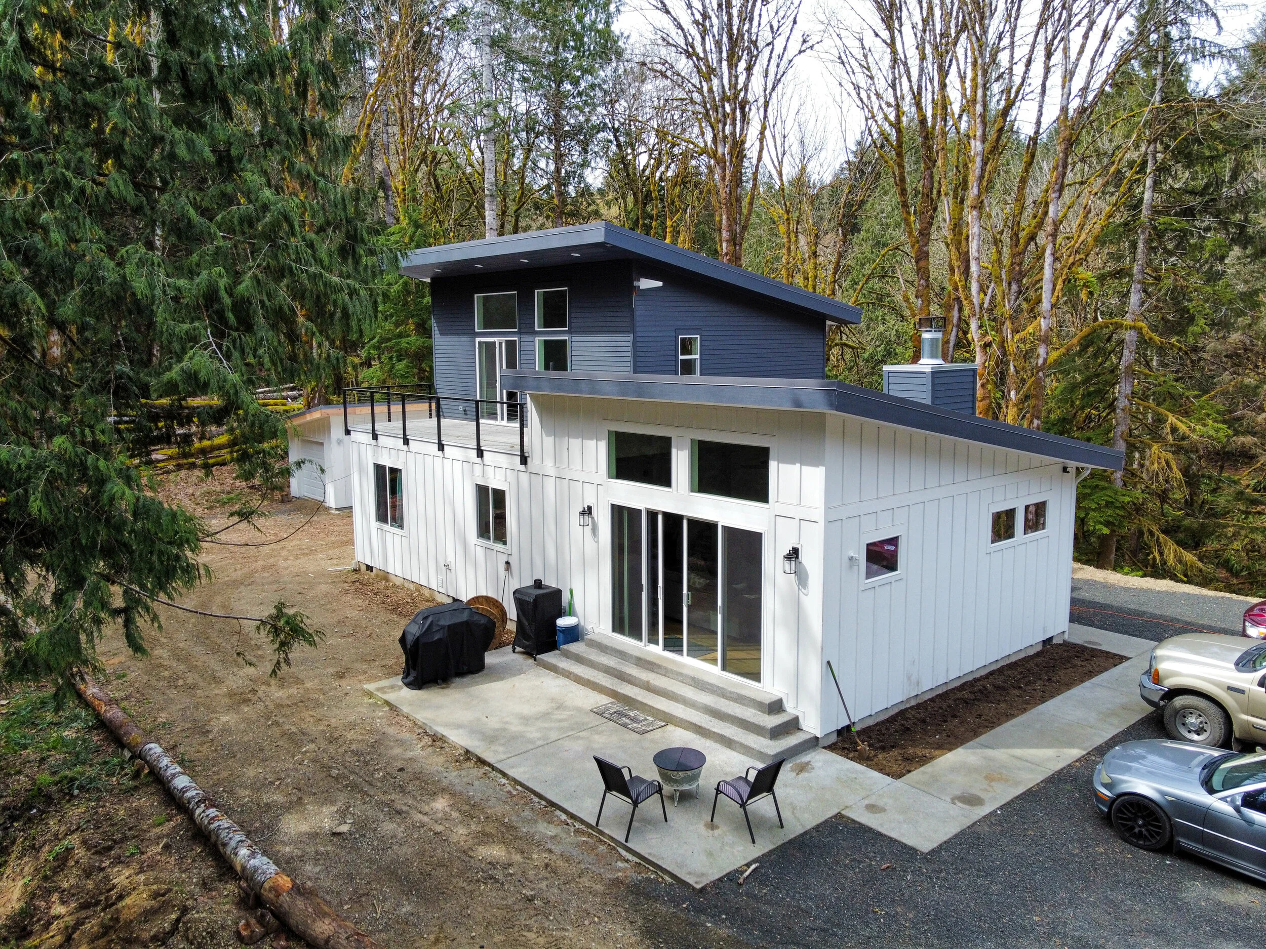 Bobbie's modern custom home in Shelton featuring contemporary design with metal roof and upper deck - FoxHead Construction Mason County
