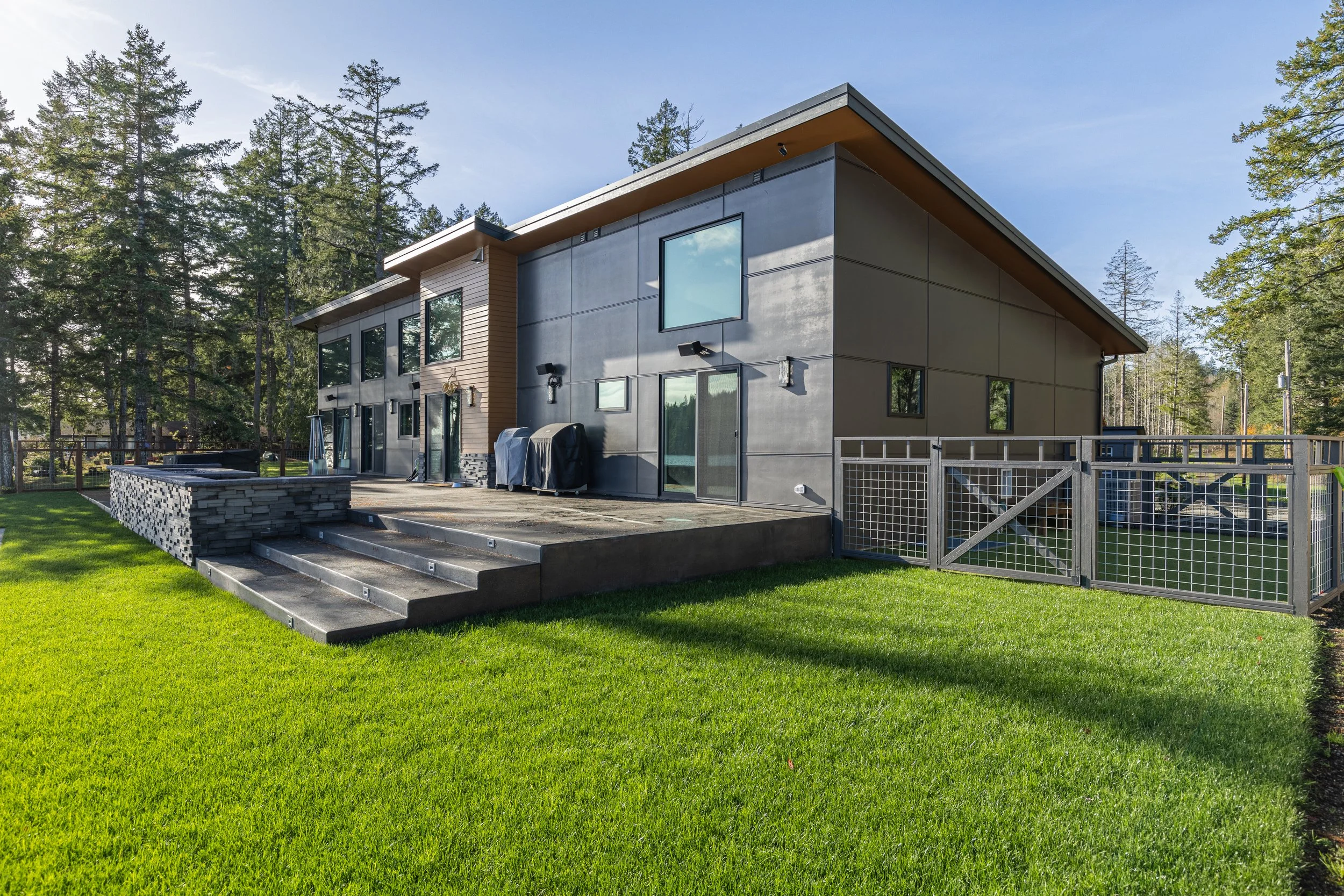 Agoados' contemporary custom home on Pickering Passage featuring modern exterior with detached shops - FoxHead Construction Mason County