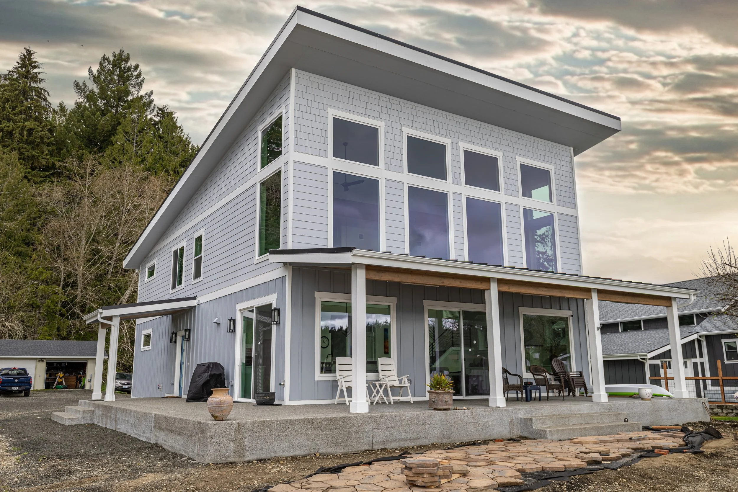 Bayview modern coastal custom home featuring contemporary design with wraparound covered porch - FoxHead Construction Mason County