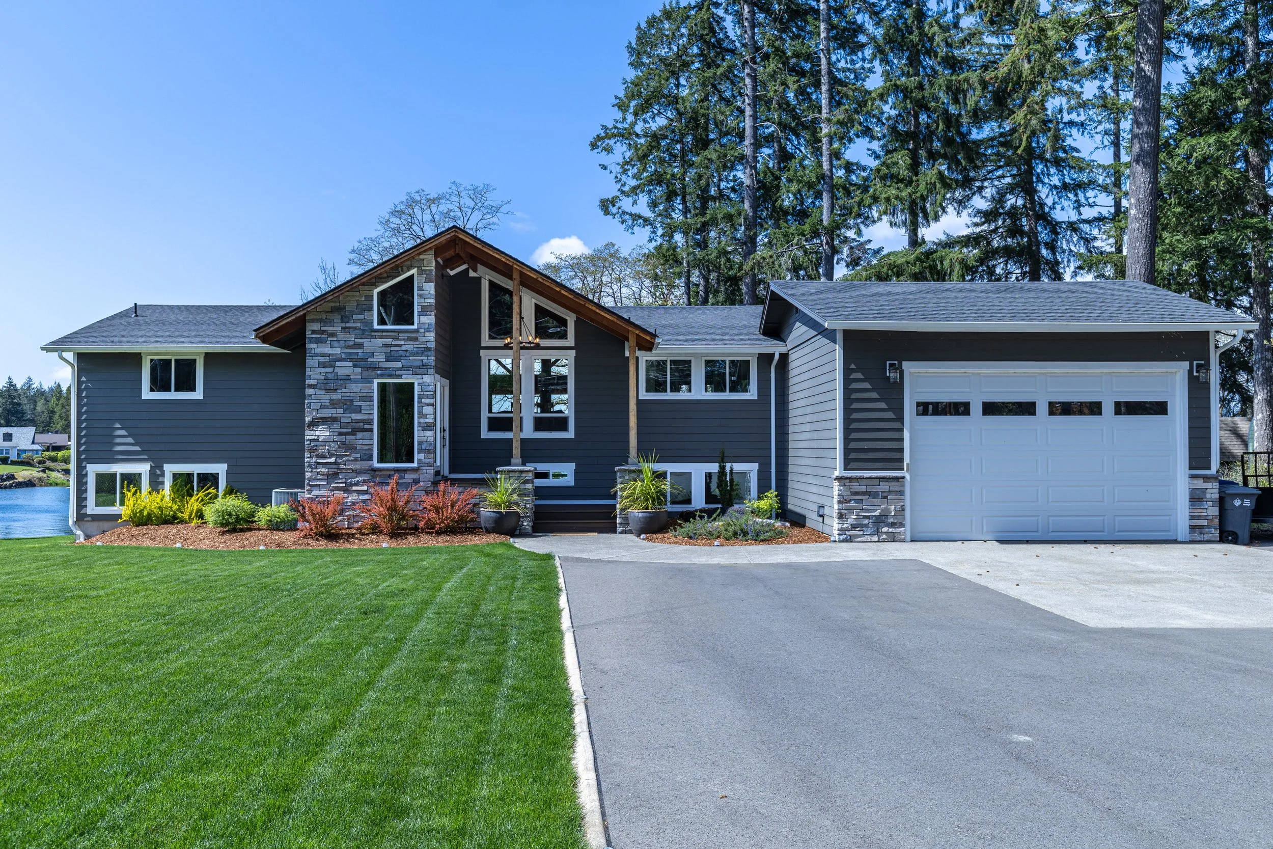 Island Lake House whole home remodel featuring lakefront exterior with multi-level deck - FoxHead Construction Mason County
