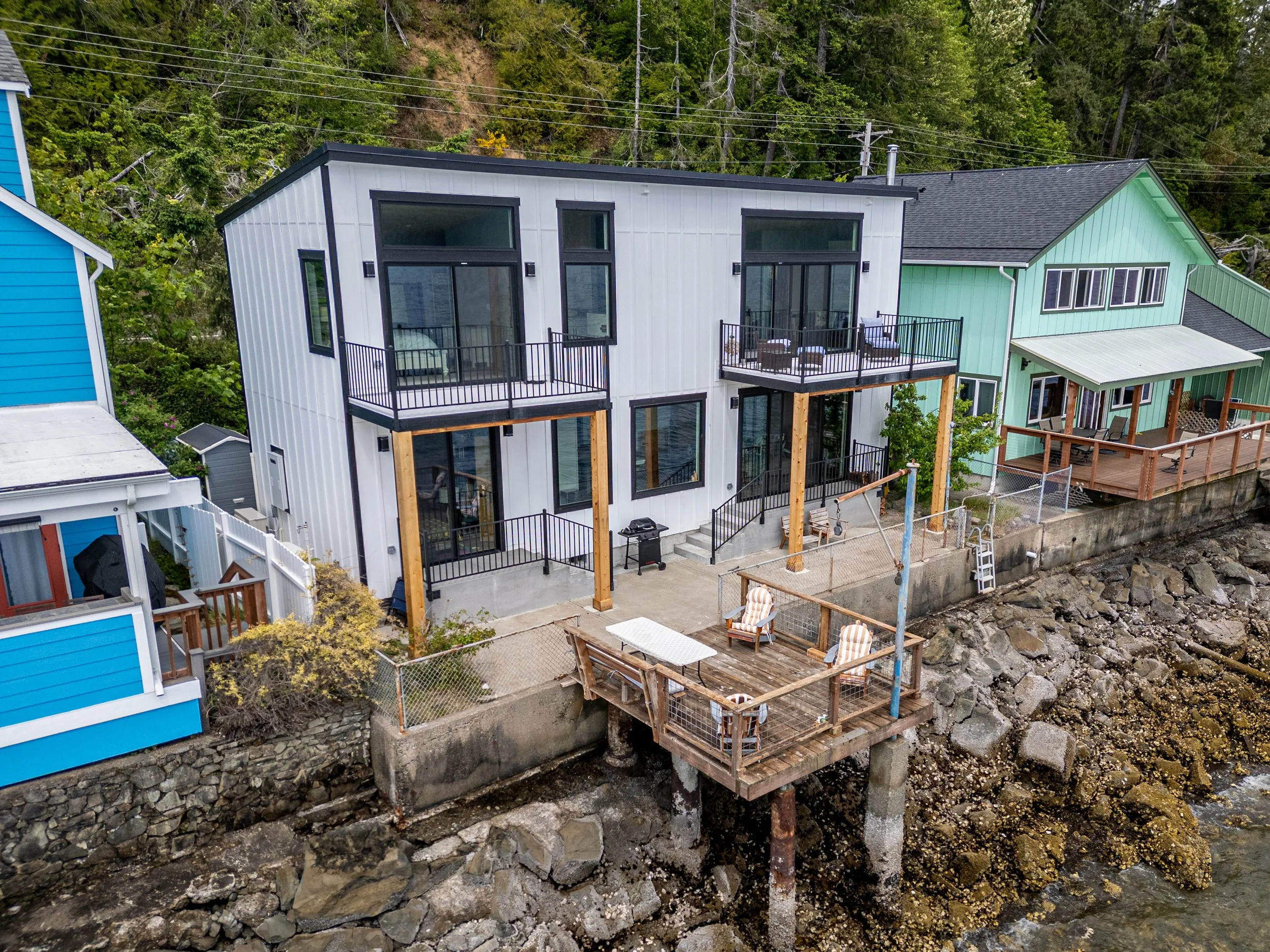 Virginia's custom waterfront home in Hoodsport featuring multi-level decks with water views - aerial view - FoxHead Construction Mason County