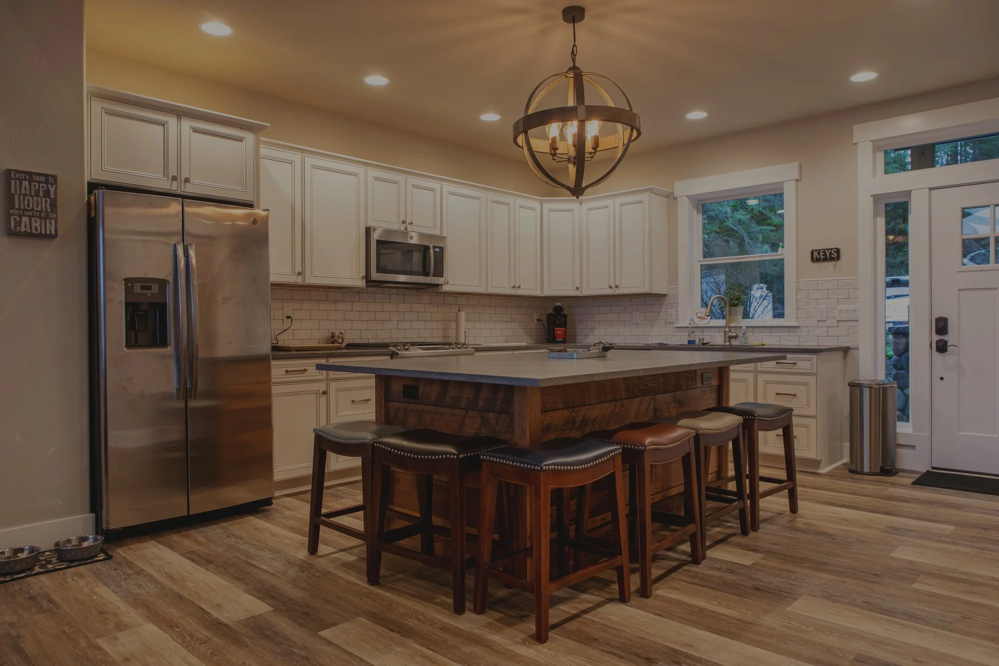 Chris's lakefront custom home on Mason Lake featuring rustic kitchen with wood island and timber frame covered porch - FoxHead Construction Mason County