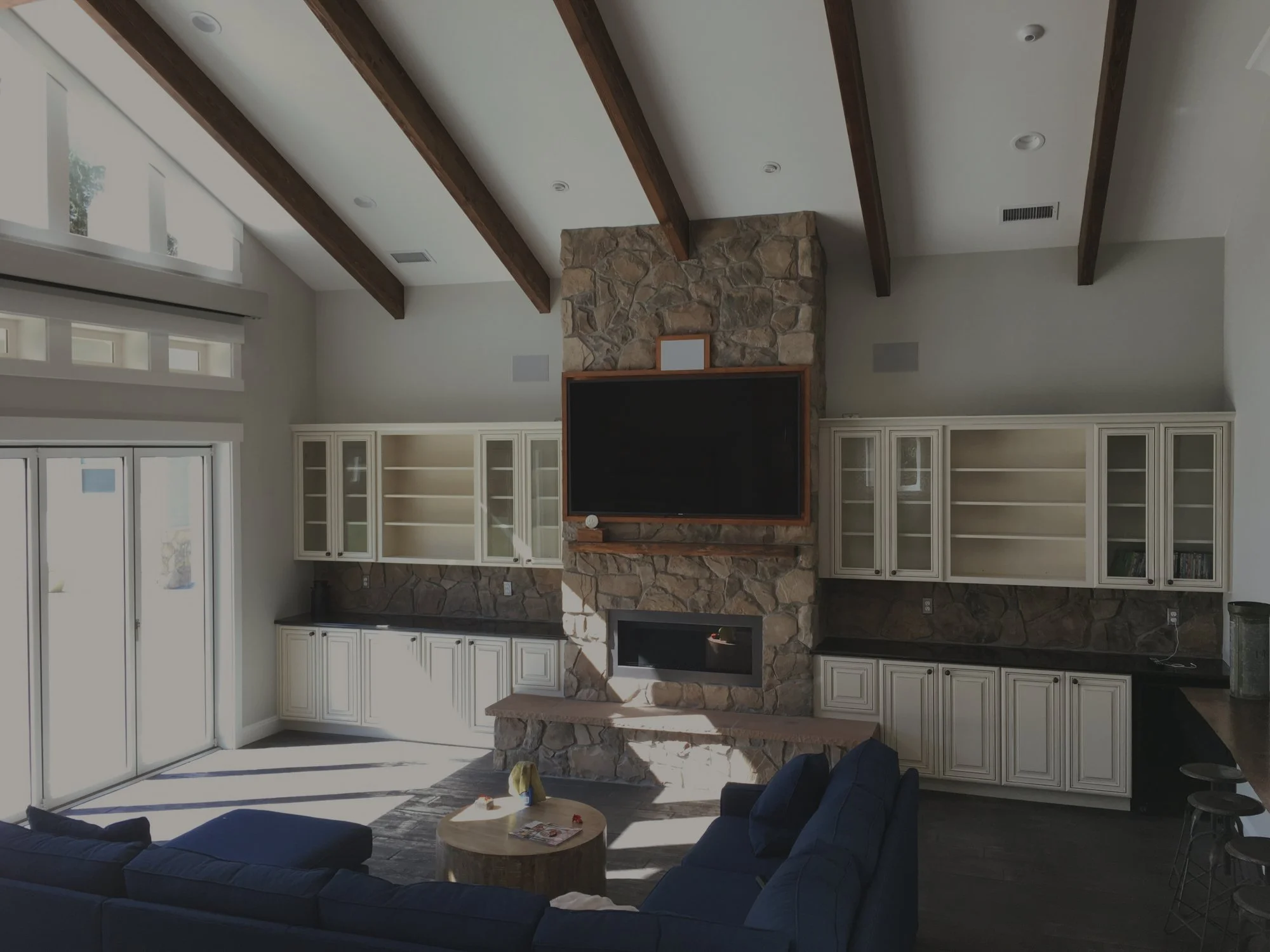 Ross's whole home remodel in Olympia featuring living room with stone fireplace and vaulted ceilings - FoxHead Construction Thurston County