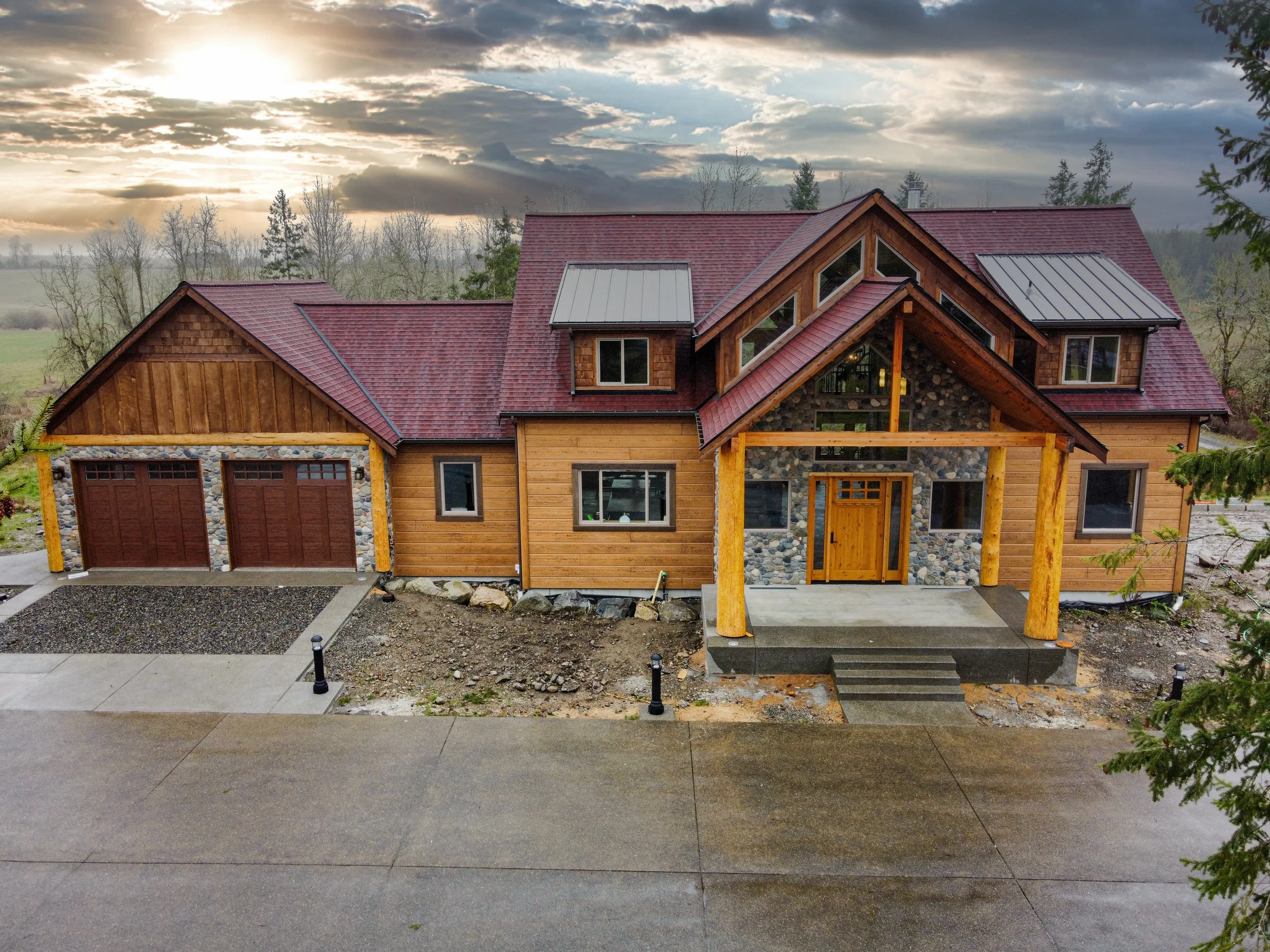Mardy's timber frame mountain lodge custom home in Roy featuring red metal roof and log-inspired design - FoxHead Construction Pierce County